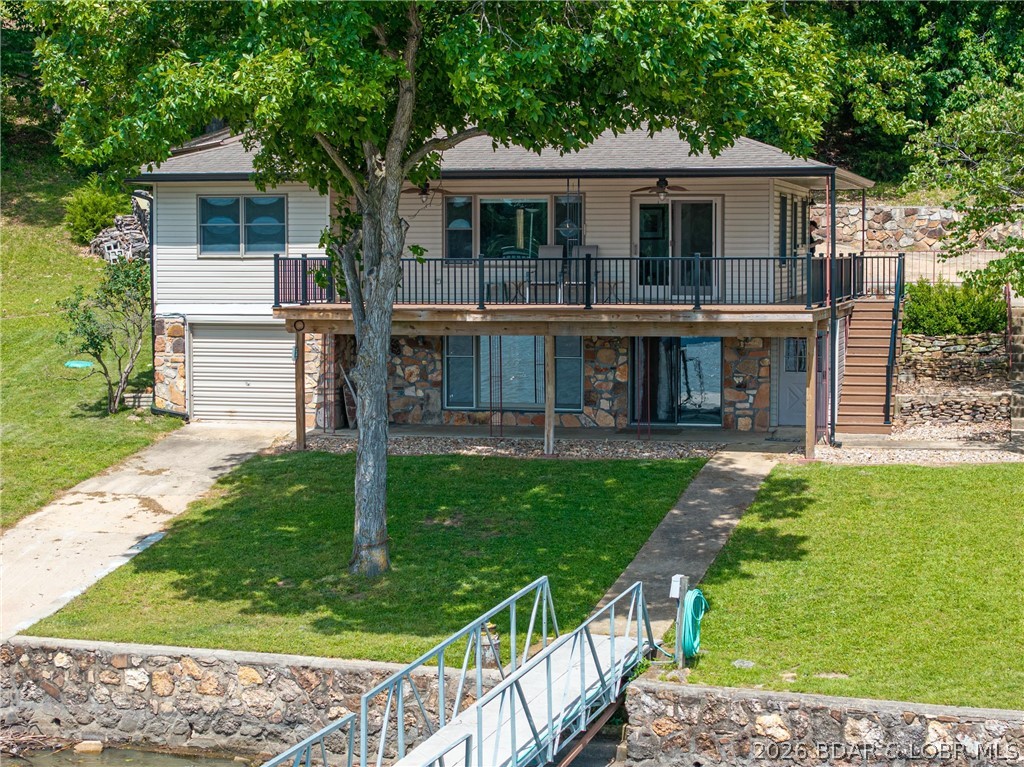 Charming Lakefront Haven at the 52 MM – A Lifetime of Memories Awaits! Discover the true spirit of Lake of the Ozarks. For the first time since 1978, this cherished lakefront home is ready for its next chapter. Lovingly owned by one family for nearly five decades, it’s filled with warmth, character, and timeless lake charm. Offering 3 bedrooms (1 nonconforming), 2 baths, a cozy kitchen and fireplace, family room, living room & two levels, this is the kind of home that feels welcoming the moment you step inside. Enjoy a prime 52 MM location with the perfect blend of peaceful lake living and great water access. The steel & concrete dock is ideal for boating, swimming, fishing, and endless summer fun. A gentle lakeside yard—rare at the lake—is perfect for gatherings, yard games, or relaxing by the water. The detached garage provides space for vehicles, lake toys, storage, or a workshop. Beautifully preserved vintage details give this home a cozy, nostalgic personality you simply can’t recreate. Don't forget the boathouse. If you’re looking for a lake house that truly feels like home, this is the one.  If you listen with your heart, you can already feel the love and laughter here.