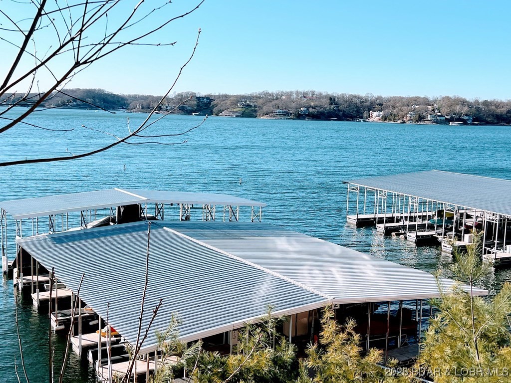 Discover your dream getaway at Lake Ozark! This spacious 3-bedroom, 3-bath condo is ideally located at the 2-mile marker, offering beautiful views and easy water access. Enjoy a bonus sunroom, perfect for relaxation, along with a 10 x 28 dock slip with operational 10,000 lb lift, 2 PWC spaces (new ride on lifts available to purchase) and a 1-car garage. Complex amenities include: two pools (one lake side), playground, dog park, docks with electricity and water, elevators for access to the lakeside pool and marina, garages and a clubhouse for community fun. With no gravel roads, accessing your new home is a breeze. Plus, you're just moments away from dining and entertainment on Horseshoe Bend and Bagnell Dam. Whether you seek a full-time residence or a weekend retreat, this condo provides the perfect blend of comfort and recreation. Don’t miss this opportunity—schedule your showing today! Investment Opportunity! These units can be rented short-term on-Air B&B. Listed by Owner/Agent.