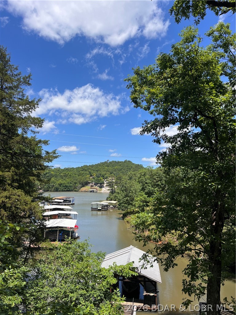Rare opportunity to own a private waterfront retreat with approximately 55 feet of shoreline tucked away in a peaceful cove.  Presenting an excellent opportunity for investors, builders, or buyers seeking an affordable path to waterfront ownership. The existing home is an older modular residence that has been expanded over the years and is being offered primarily for its land and location value, located just minutes from Highway 5, popular lakefront destinations, restaurants, and grocery stores.
Whether you're looking for a complete renovation project or envisioning a custom lakefront build, this property provides a unique canvas to create something truly special. 
As an added bonus, the HOA offers a private boat ramp for easy lake access, along with trailer and dry-storage facilities, making it simple to launch, store, and enjoy your boat year-round.
Come stand on this property and feel the serenity of water views and mature trees and take in the best of the Ozarks. Bring your vision and transform this hidden gem into the lakefront getaway you've always wanted. Property is being sold "as-is."