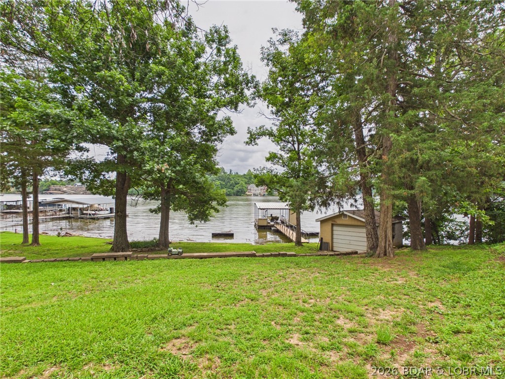 Don't miss this exceptional 4-bedroom, 2-bath lakefront home located at the 5 Mile Marker of the Little Niangua Arm. Situated on a rare flat lot with beautiful channel views, this property offers the perfect combination of convenience, functionality, and lake lifestyle.  Inside, you'll find approximately 2,400 square feet of living space, including a small workshop area in the basement—ideal for hobbies, storage, or lake projects. The home also features an oversized one-car attached garage and a detached boathouse/garage, providing plenty of room for vehicles, boats, and lake toys.

The waterfront includes a single-slip dock, along with ample shoreline and water frontage to accommodate a larger replacement dock (subject to permitting), giving you room to expand your lakefront experience.
Enjoy blacktop roads all the way to the driveway, abundant parking for family and guests, and easy access to the water with a gently sloping lot that's becoming increasingly difficult to find at the Lake of the Ozarks.
Whether you're looking for a full-time residence, weekend retreat, or investment opportunity.  This home deserves a spot on your short list—schedule your private showing today!