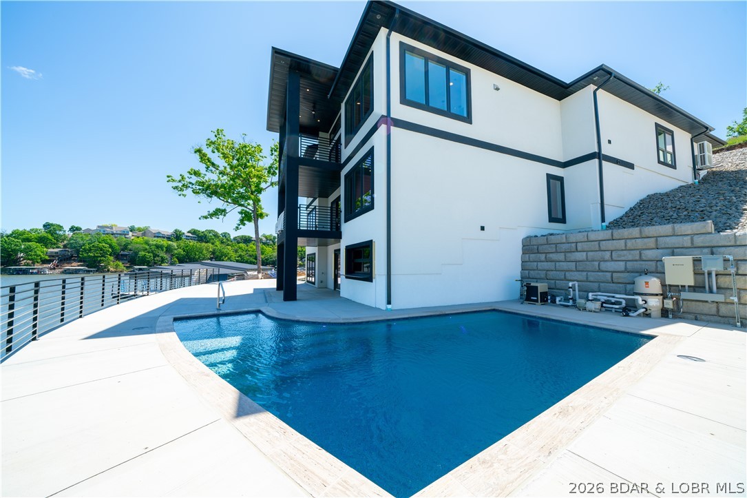 Nestled along the breathtaking shoreline of the Lake of the Ozarks, this brand-new luxury estate offers the perfect blend of modern elegance, upscale comfort, and unforgettable waterfront living. Featuring 5 spacious bedrooms and 6 beautifully designed bathrooms, this custom-built home was thoughtfully crafted with high-end finishes, open-concept living spaces, and panoramic lake views from nearly every room. The heart of the home showcases a stunning kitchen complete with premium appliances, custom cabinetry, oversized island seating, and seamless flow into the expansive living and dining areas highlighted by soaring ceilings and walls of glass overlooking the lake Designed for both entertaining and relaxation, the home offers multiple indoor and outdoor gathering spaces that capture the beauty of lakefront living. Step outside to your private resort-style oasis featuring an incredible in-ground pool, spacious sun deck, and breathtaking sunset views across the lake. Rarely does a brand-new waterfront home of this caliber become available — offering luxury, privacy, recreation, and unforgettable views all in one extraordinary package. Brand new dock is available for $175,000.