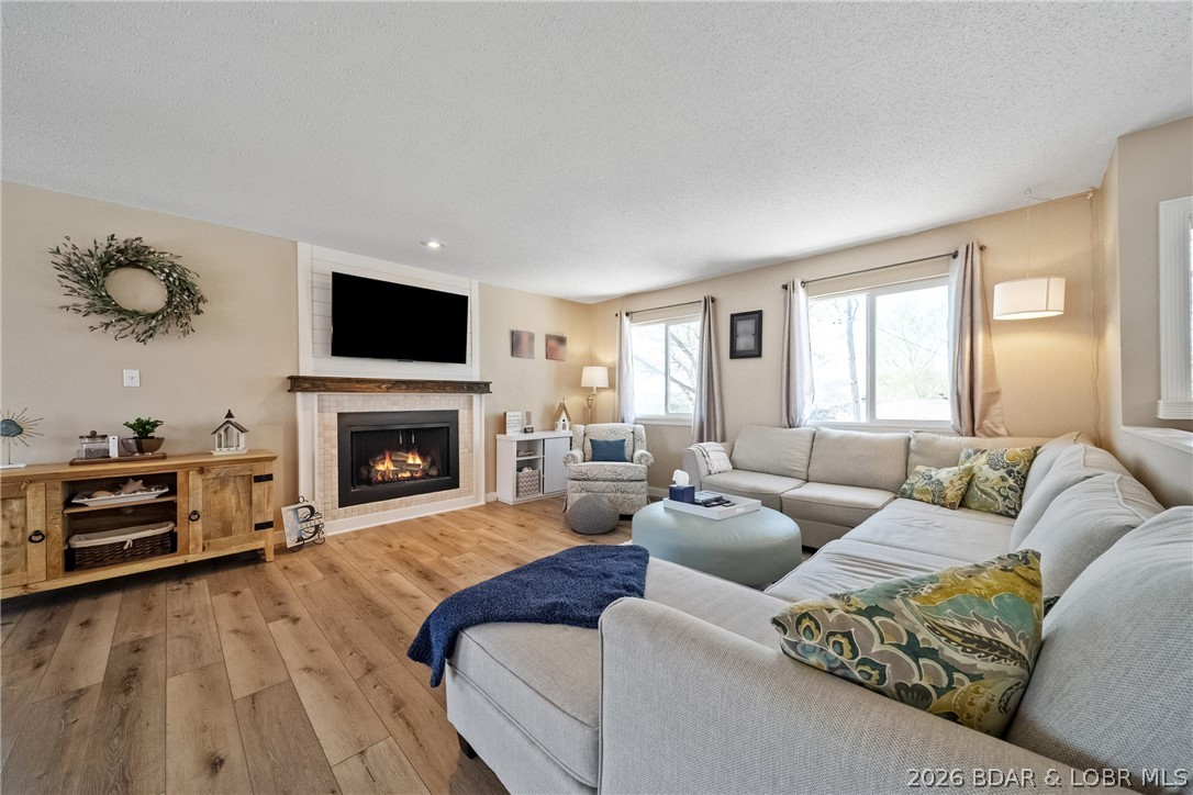 Location like this is hard to find, Osage Beach, an established neighborhood, nearly 2 acres and a lake view. This unique offering includes the home plus 5 additional lots stretching down toward the water, giving you privacy, usable land, and serious upside. The setting is outstanding—enjoy the current lake view overlooking the Grand Glaize arm and the State Park, or open it up even more with additional tree clearing. The extra lots are perfect for a garage, shop, or future development, yet today they provide a park-like setting with shade, nature, and a great firepit area. The home shows extremely well with numerous updates including a gorgeous kitchen with new cabinetry/quartz tops, new flooring, updated baths, fresh paint, newer HVAC, and roof. Light, bright, and functional with 4 bedrooms, 3 baths, 2 offices, a lakeside sunroom, and lower level with family room, workshop space, and storage. Plenty of parking (5–6 cars) & an easy walk or golf cart ride to the community dock with 10x26 slip, hoist included.  City water, sewer, blacktop roads—this checks every box. At this price point, you simply won’t find this combination of location, land, view, & dock access in Osage Beach.
