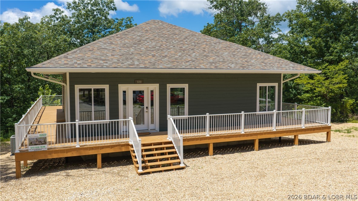 New construction, 5 private acres, gated entry, and resort-style amenities—this Lake of the Ozarks property checks all the boxes. Located in a luxury community next to Old Kinderhook, the 4-bedroom, 3-bath home offers 2,400 square feet and flexibility as a full-time residence, second home, or short-term rental. The open-concept main level features vaulted ceilings, generous kitchen counter space, the primary suite, a second bedroom, and an additional full bath. The lower level includes a second living area, two more bedrooms, a third full bath, and laundry. Enjoy the surrounding nature and wildlife from the large wraparound deck or covered lower patio with hot tub. Flat parking and ample acreage provide room for a future shop. Community amenities include a new clubhouse, indoor and outdoor heated pools, fitness center, spa, pickleball courts, maintained streets, and a convention center under construction. Minutes from Camdenton Square, Ballparks National, golf, and popular dining. Furniture, appliances, golf cart, and hot tub are included. Community roads are planned to be paved after construction is complete.