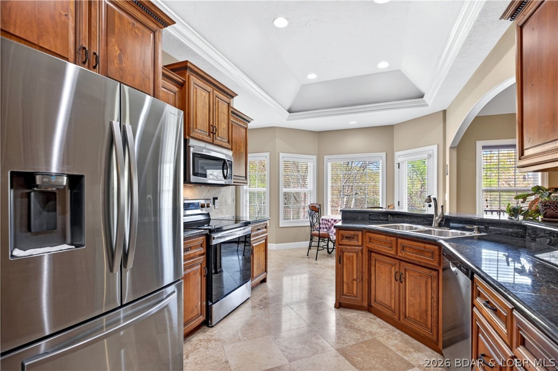 Tucked into the peaceful Deer Path Estates community, 132 Antler Point in Linn Creek offers comfortable one-level living with the space and setting to truly feel at home. This 4-bedroom, 3-bath brick home features vaulted ceilings, an open main living area, and a bright kitchen and dining space designed for everyday living and easy gathering. The private primary suite offers a relaxing retreat, while the spacious deck overlooks a beautiful wooded backdrop and gently sloping yard. With a 3-car attached garage, .24-acre lot, and convenient access to Hwy 54, this property combines privacy, practicality, and a welcoming feel in the Camdenton School District. New roof May 2026!