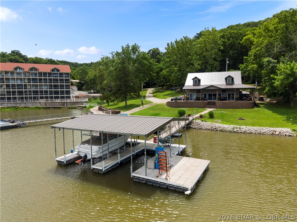 Developer's Dream on the Big Niangua – Turnkey Home + Prime Development Potential! Rarely does an opportunity like this come available on the Lake of the Ozarks. Situated on nearly 2 acres at the 14 Mile Marker of the Big Niangua, this exceptional property offers 258 feet of lakefront, a turnkey 3-bedroom, 3-bath home, and incredible development potential with multifamily zoning already in place. The beautifully maintained home is move-in ready and designed for entertaining, while the expansive, ultra-flat parcel provides endless possibilities for future growth. With water and sewer infrastructure available for up to 20 additional hookups, this property is perfectly suited for tiny homes, RV sites, multifamily development, vacation rentals, or a private family compound.
Enjoy effortless lake living with your own private boat ramp and a cove-protected concrete dock featuring a 12x30 slip & 10x24 slip, all positioned to capture stunning main-channel views while offering calm water protection. Developers will appreciate the ability to relocate and reconfigure the existing dock into a larger community dock to accommodate additional residences and maximize the property's potential.