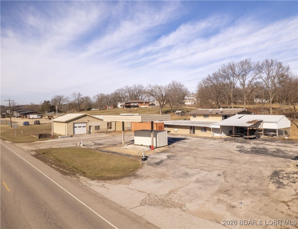 Home & Business! Endless potential meets everyday convenience at this highly visible Hwy 42 location in Brumley. This rare commercial and residential property offers the opportunity to live and work in one place while benefiting from growing highway traffic. The 3-bedroom home features main-level living, an open floor plan with vaulted ceilings, LVP flooring, updated windows, and a modern kitchen with custom cabinetry, tile backsplash, large island, gas stove, and hard-surface countertops. A covered patio, attached carport, and walkout lower level add everyday functionality. The former convenience store includes office space, kitchen area, two half baths, a shower, ample storage, and a large walk-in cooler. Multiple additional outbuildings provide shop, garage, and work space with overhead doors for equipment or vehicle access. Previously operated as a gas station, convenience store, bait shop, deli, and hardware location, this property offers excellent highway frontage with limited nearby competition and increasing traffic. Located in the School of the Osage District and a short drive to Lake of the Ozarks, it’s a versatile live-and-work opportunity.