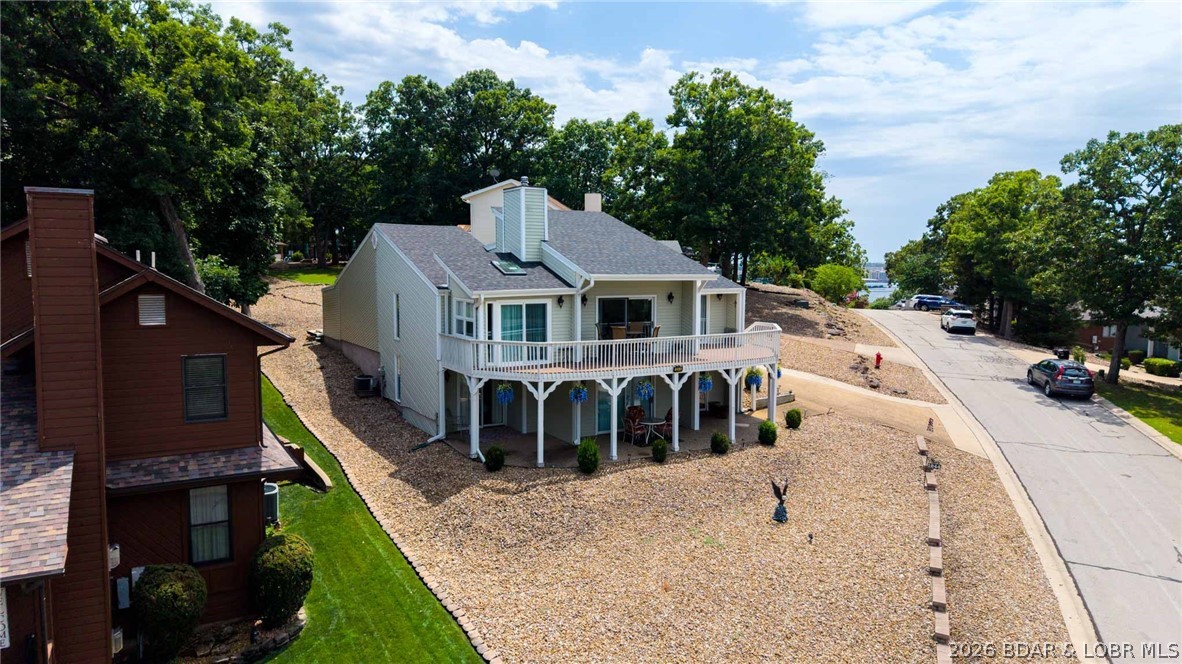 YEAR ROUND MAIN CHANNEL VIEW, a rare 3-car garage, and over 2,400 square feet—all in one of Osage Beach's most sought-after neighborhoods for under $475K! This 3 bed, 3 bath home in Summit Point offers a combination that's becoming increasingly difficult to find. Vaulted ceilings and walls of windows fill the home with natural light while showcasing the incredible lake views from the spacious living area and oversized deck. The main-level primary suite features an updated bath, walk-in closet, and private office/den (den not serviced by HVAC), while the lower-level patio is already wired and ready for your future hot tub. Numerous updates have already been completed including flooring, roof, HVAC, windows, sliders, blinds, and more, allowing the next owner to simply move in and enjoy. Residents love Summit Point for its low HOA dues, community pool, lighted tennis and pickleball courts, basketball court, playground, and firepit area. Golf-cart-friendly access to Dierbergs Markets, Ace Hardware, shopping, dining, and everyday conveniences makes this one of Osage Beach's premier neighborhoods. Opportunities like this under $500K don't come around often. Long term rentals allowed!