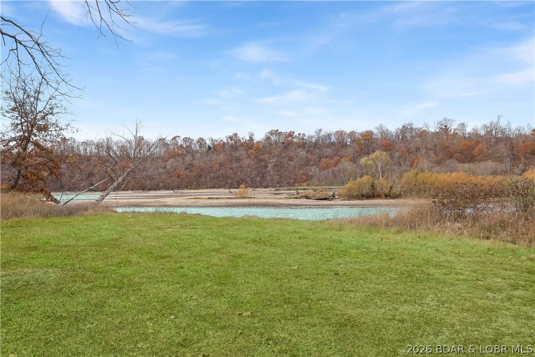GREAT VALUE! Beautiful home on 4.49+ wooded acres with deeded Lake of the Ozarks access offers privacy, usability, and endless possibilities. Ideal for homesteading, bird watching, hunting, wildlife enthusiasts, or a hobby farm retreat. This energy-efficient home features 3 bedrooms (1 non-conforming), 1.5 baths, and an open-concept layout connecting the kitchen, living, and family rooms. The spacious primary suite includes an oversized jacuzzi tub/shower and antique mirror. Flexible floor plan allows potential for additional bedrooms and converting the half bath to a full bath. Gently rolling acreage includes virgin timber, room for gardens, trails, animals, or a shop. Abundant wildlife makes this a hunter’s paradise. Property also features a private well, gated circular driveway, utility room with washer/dryer and sink, plus a 10x20 metal shed with electricity for storage or equipment. Additional adjacent 18.68 acres with creek available (MLS 3582431).