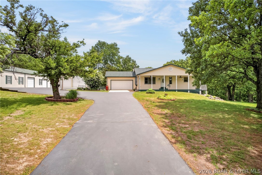 LIVE, WORK & PLAY!
This incredible property offers over 7,800 sq ft of shop space, with a 3 bay 100x50 shop area as well as a 70x40 RV storage bay.  Shop can easily accommodate 15+ vehicles, along with a dedicated workshop and bathroom, a dream setup for hobbyists, business owners, or collectors.
Perfectly situated on a sprawling 4+ acre lot, just 10 minutes from the heart of Osage Beach, this property delivers both privacy and convenience.
Relax and unwind with stunning sunset views from the covered front porch or entertain all summer long on the back deck featuring a pool and BBQ area—ideal for gatherings.
Inside, you’ll love the open floor plan with convenient main-level living. The bright and inviting four seasons room offers year-round enjoyment and direct access to the fenced backyard and pool deck.
The lower level adds even more living space, complete with a cozy wood-burning stove, an additional bedroom with walkout access, a full bath, and plenty of storage. NEW ROOF, new well pump 2022, ultraviolet water purification system and new kitchen appliances in 2022!!