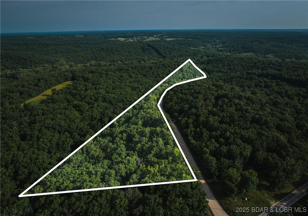 Escape to 9.5± acres of untouched Ozark timberland just minutes from Lake of the Ozarks. This beautiful parcel sits along a quiet county-maintained road, offering easy drive-in access while still feeling tucked away from the world. Towering hardwoods, gentle ridgelines, and the natural rise-and-fall of the terrain create multiple possibilities for a future home, cabin, or secluded barndominium with wooded views. Owner is a licensed agent.

The moderate slope provides elevation and privacy without sacrificing buildability. Enjoy the freedom to carve your own driveway, shape your vision, and position your build site amongst the trees. Wildlife trails wind through the property, making it ideal for those who enjoy exploring, hunting, or simply unplugging under a canopy of leaves.

Opportunities this close to the lake rarely stay on the market long—bring your plans, your imagination, and claim a piece of the quiet countryside before it’s gone.