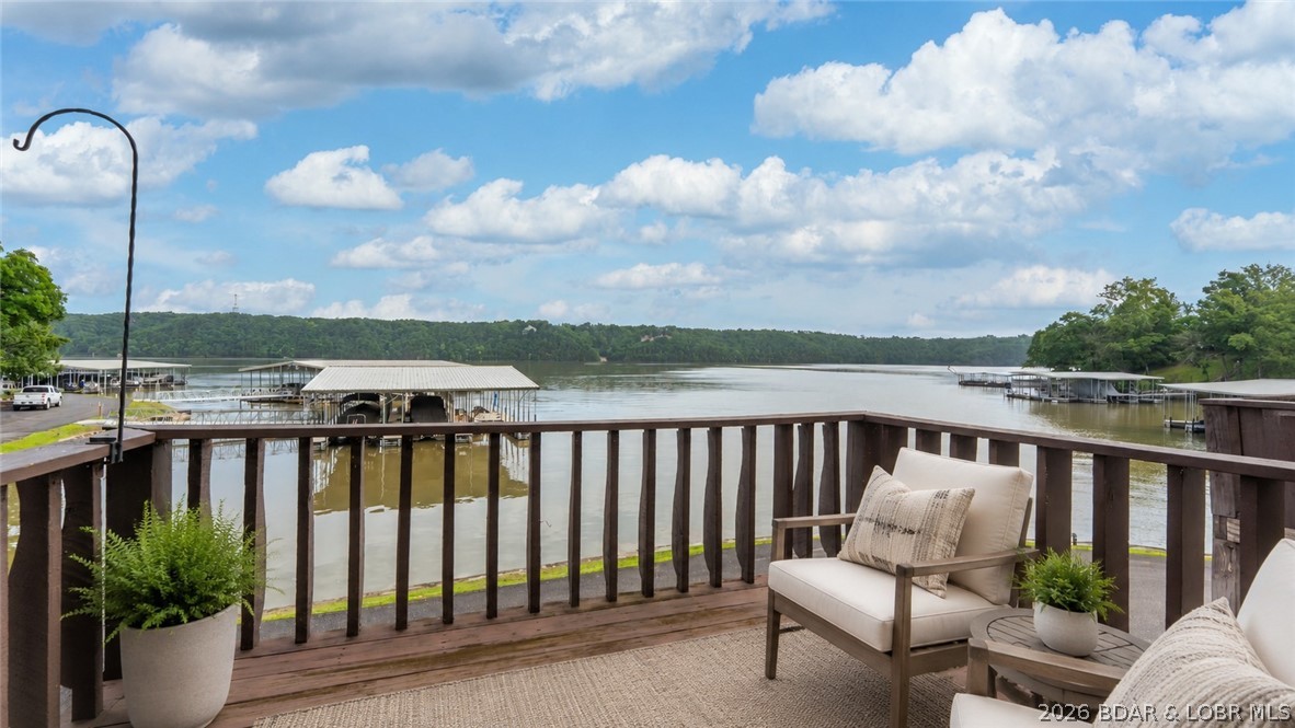 An opportunity to have a 6 bedroom condo is RARE! 6 bedrooms & 3 bathrooms on the water, no unit above you, with two full levels, is an incredible value for the space. Assessments have also just REDUCED over $1,500 per year! This unit comes freshly painted with updated countertops and fixtures, offers a bright & open main level and panoramic lake views from the living room, kitchen AND 4 bedrooms for a true “on-the-water” feel! The primary suite features a private bath, stone wood-burning fireplace, and private balcony. Main level also includes laundry and an additional full bath. Upstairs are 5 spacious bedrooms and another full bath—ideal for large groups or strong rental potential (3 months or more). Just steps to your 14x30 boat slip on Dock 5 (6th slip on right) with unobstructed views. Right out your door is the community pool, pet area and convenient parking. Incredible views of the Osage 29MM near Paradise, Margaritaville, dining, golf and shopping. If you want space, views and a prime lakefront location — this one delivers.