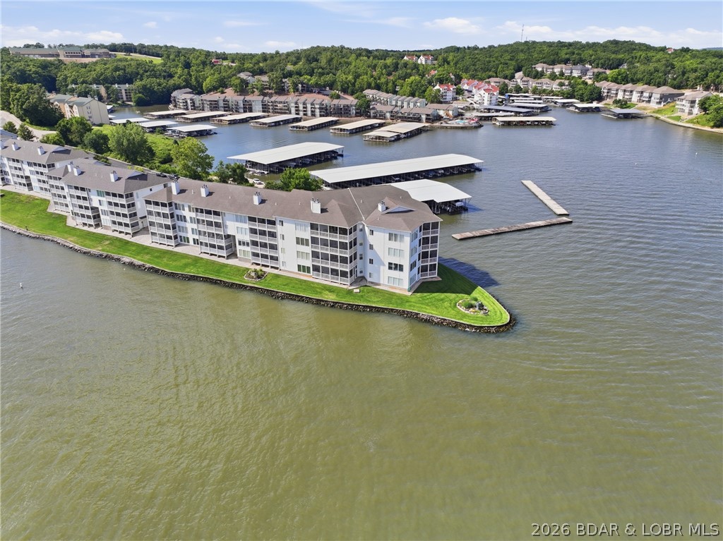 Regatta Bay condominium with walk-in level entry and an east-facing main channel view. Features 3 bedrooms, 3.5 baths, a screened deck, wood-burning fireplace, and 10-foot ceilings throughout. Floor-to-ceiling lakeside glass windows showcase stunning lake views, while crown molding adds elegance throughout. Both guest bedrooms are private suites. The living room includes a wet bar, and the kitchen bar  provides additional workspace and seating.  Foyer, kitchen and all bathrooms have tile floors. The primary suite features a walk-in shower and walk-in closet.  All new windows in living room and  primary bedroom.