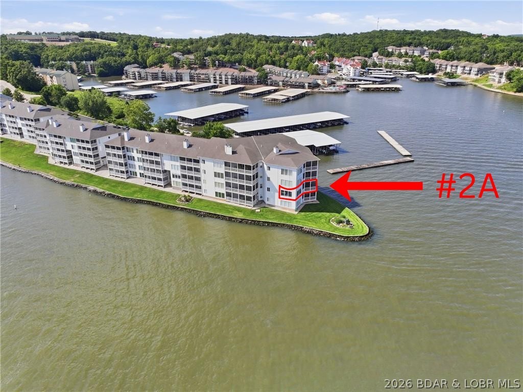 Regatta Bay condominium with walk-in level entry and an east-facing main channel view. Features 3 bedrooms, 3.5 baths, a screened deck, wood-burning fireplace, and 10-foot ceilings throughout. Floor-to-ceiling lakeside glass windows showcase stunning lake views, while crown molding adds elegance throughout.  The living room includes a wet bar, and the kitchen bar  provides additional workspace and seating.  Foyer, kitchen and all bathrooms have tile floors. The primary suite features a walk-in shower and walk-in closet. Both guest bedrooms are private suites with full bathrooms and one with walk-in closet. All new windows in living room and primary bedroom.