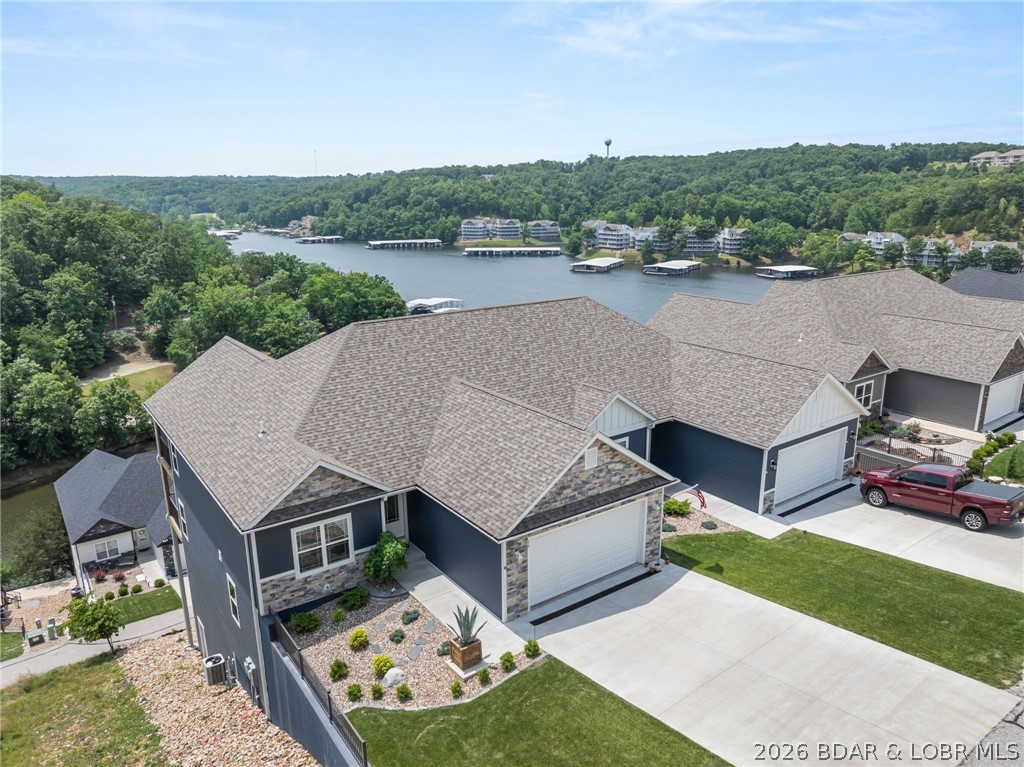 Experience the ultimate lake lifestyle at this stunning 4-bedroom, 3-bath luxury villa in the exclusive, gated Villas at Tuscany w/Big Views! Located at the 1MM of the Big Niangua, this masterpiece offers breathtaking lake views & effortless, maintenance-free living, modern luxury & design. Step into a sun-drenched open floor plan with vaulted ceilings, wall of windows, & a cozy electric fireplace. The gourmet kitchen is a chef’s dream w/granite countertops, custom cabinetry, stainless appliances, & an oversized island perfect for entertaining. The primary suite is a true retreat, boasting a detailed tray ceiling, custom tiled walk-in shower, & a walk-in closet w/built-ins. A 2nd bedroom & laundry room complete the main level for maximum convenience. The lower level features a large family room, 2 additional bedrooms, & huge storage area. Relax on one of 2 expansive decks, including a screened-in upper level for year-round enjoyment. Additional Perks - 12x36 Boat Slip. Garage: 2-car attached w/epoxy flooring; Amenities: Lakeside pool, pickleball, fire pit, & clubhouse; Access: Golf cart-friendly paths w/ no-step dock access. Don't wait—this turn-key gem is priced to sell!