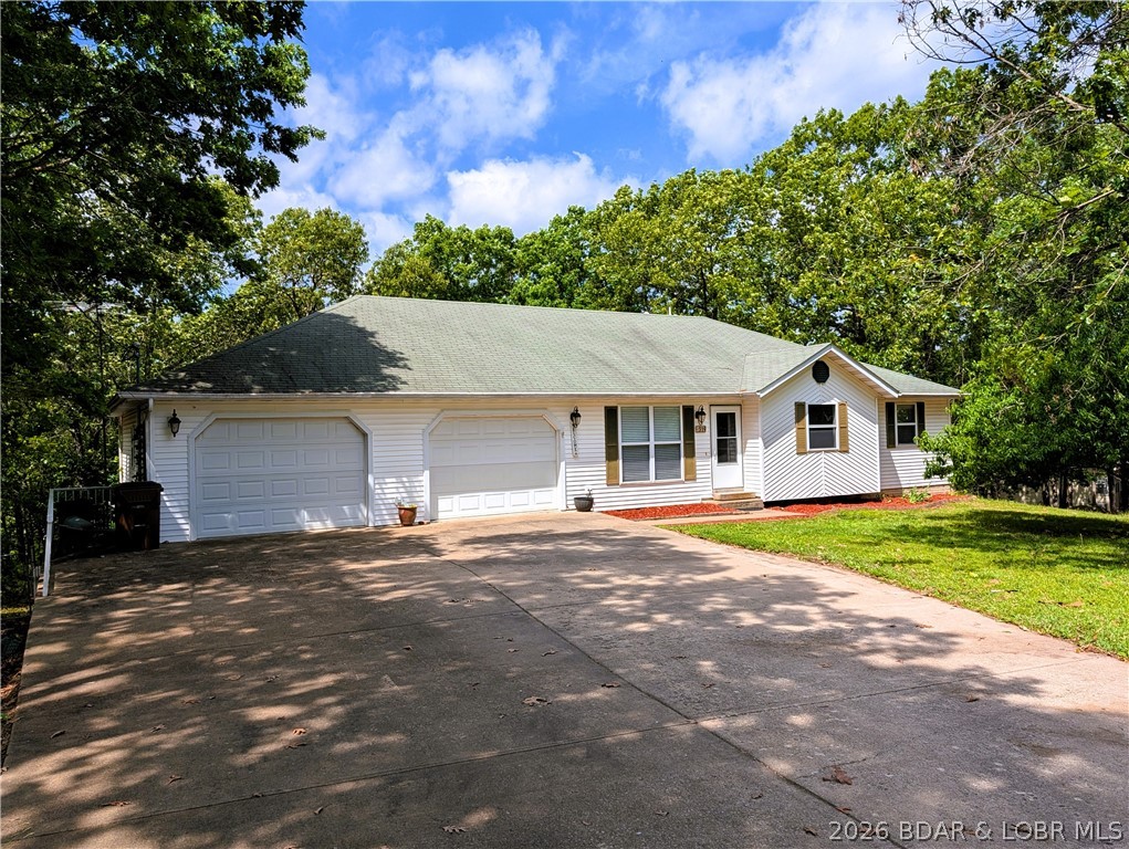 Welcome to this 4-bedroom, 3.5-bath home offering oversized living spaces, abundant storage & flexible floor plan. Double lot in Camelot Estates.  Step inside to discover a stunning great room with vaulted ceilings, rich wood flooring & open dining. Spacious kitchen for the aspiring home chef, abundant wood cabinetry & counter space, SS appliances, gas cooking. Laundry room & half bath .Main-level suite offers walk-in closet shower & jetted tub. One of the standout features is the bright & inviting sunroom just off the kitchen surrounded by windows to spend a morning watching birds or an evening enjoying the sunset through the trees. Finished lower level offers versatile floorplan & 4th bedroom, full bath, family room &  utility room & sunroom. Convenient dog door to fenced yard. Car enthusiasts, boaters &  hobbyists will appreciate the attached finished oversized 3-car garage & workshop area with a large concrete driveway. Utility garage has more storage. Recent updates include HVAC, water softener, water heater & new roof on the way. $40 month offers amenities,2 swimming pools, clubhouse, playground, boat ramp, fishing dock, tennis courts & more. Offering $5,000 carpet allowance.
