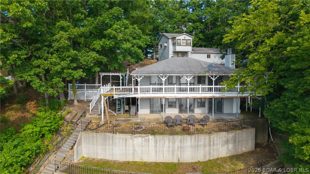 Situated on an exceptional main channel lot with breathtaking views, this 4 bedroom, 3 bath lakefront home combines location, space, & opportunity. The property also features an oversized detached shop/garage with an apartment above & a large poured concrete circular driveway that creates excellent access & abundant parking. The open floor plan is designed to make the most of the lakefront setting, with expansive living areas on both levels & an abundance of lakeside windows that keep the breathtaking main channel views front & center throughout the home. At the water you'll find the true showstopper, an incredible 3 well concrete dock featuring 2 boat slips, a spacious sun deck, & a double PWC slip. This home is being sold in its present condition & is priced to reflect the opportunity for improvements. This property is perfect for buyers looking to build value while enjoying the lake. Opportunities to purchase this type of view with this much infrastructure, & amazing dock at this price point are becoming increasingly rare, making this an exceptional chance to secure your place at the lake before someone else does.