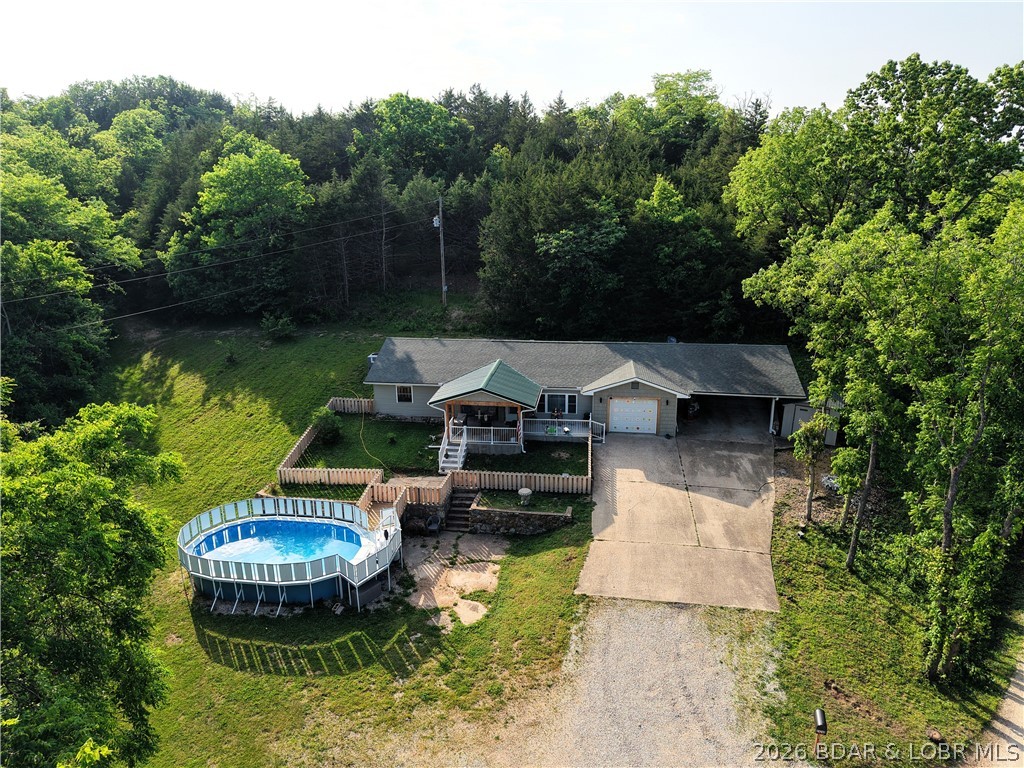 LOCATION is key for this lovely, remodeled home ready for a new family! 3 miles to the Gravois Public Access to the Lake of the Ozarks to launch your boat or fish off the public dock. Short drive to the Ozark International Raceway, shopping, medical care and dining as well as all of the amenities the Lake area provides. And with blacktop to the driveway and 4.55 acres for privacy this is a package you just don't find often. The home boasts granite countertops, new appliances, new flooring, updated bathrooms and so much more! Relax on the covered deck, take a relaxing swim in the pool or a nature hike through the woods. Fenced area in the yard for your kids or pets.  This is a private homesteading opportunity ready for you to make it your own. The possibilities are endless at this delightful property, schedule your showing today!