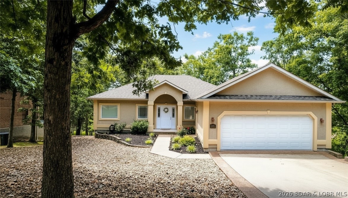 Welcome to your dream lake retreat in Timberlake Village—where comfort, style, and effortless lake living come together! This home includes a 14x36 boat slip with a 10,000-lb hoist, making lake days easy and enjoyable. Low-maintenance desert landscaping gives you more time to enjoy the clubhouse, outdoor pool, sunspaces, playground, and trailer parking. Inside, soaring vaulted ceilings and new LVP flooring (2023) highlight the open main level. A cozy gas fireplace creates a warm gathering space, while the screened-in upper deck is perfect for relaxing and watching local wildlife. The updated kitchen features quartz countertops and newer appliances. The main-level primary suite offers a peaceful retreat with a jetted tub and walk-in shower. The lower level is ideal for entertaining with a spacious family room, wet bar, additional bedrooms (5th bedroom currently used as a gym), two baths, and a walk-out deck. A mudroom with second laundry hookup, two-car garage, ample storage, and a brand-new roof (May 2025) add everyday convenience. Tucked in quiet Lickbranch Cove, yet close to lake fun—this home truly has it all. Call today! Dreams to Reality!
