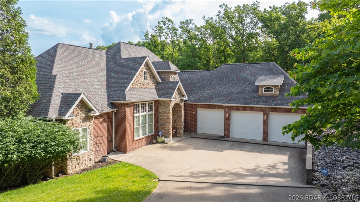 If sophistication could define a home, this stunning property embodies it perfectly – a grand and sophisticated residence. This all-brick lakefront property offers over 4,000 square feet of living space, in excess of 1,100 square feet of garage area, over 300 feet of lake frontage, and just over 9 acres, all while exuding timeless splendor. Inside, discover a Tuscany-style kitchen featuring high-end appliances, high ceilings, expansive views, luxurious spaces, four true bedrooms and a (non-conforming) bunkroom, beautiful wood flooring, rich finishes, a new wet bar, and a full bathroom. A lakeside John Deere room serves as an ideal space for outdoor tool storage or a workshop. Additional amenities include an irrigation system, security system, an attached oversized garage, and an exceptional location. Blacktop to concrete to the door, situated just 3 miles from Camdenton by land and conveniently located near Bridal Cave or Ha Ha Tonka by water. Spanning over 9 acres of lakefront paradise, there is also potential for an additional home or guest house.