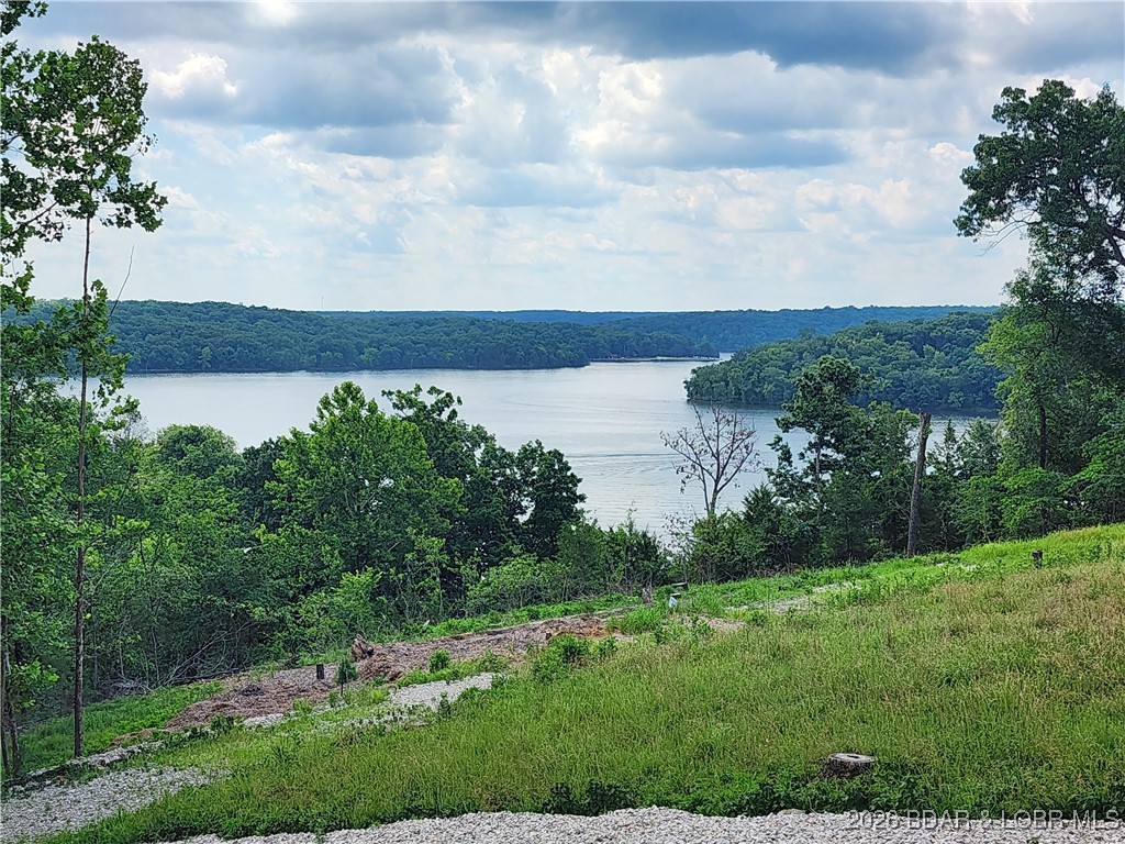 AMAZING LAKE VIEW! Discover the perfect spot to build your lake retreat on this .24-acre lot located in Kaiser, MO at the 5MM of the Grand Glaize arm of the Lake of the Ozarks. Situated within the Camdenton School District, this property offers both a peaceful setting and convenient access to everything lake living has to offer. The lot includes an 12x30 boat slip at the Park Place on the Lake Condos community dock, making it easy to enjoy days on the water. As part of the subdivision, you’ll also have access to a variety of amenities including a community pool, playground area, and more. Golf carts allowed. Lot 10 also available. The lots have upper and lower road access. Whether you’re ready to build now or looking for a future investment, this lot provides an excellent opportunity to enjoy the Lake of the Ozarks lifestyle. Call today to schedule your showing!  Dreams to Reality!