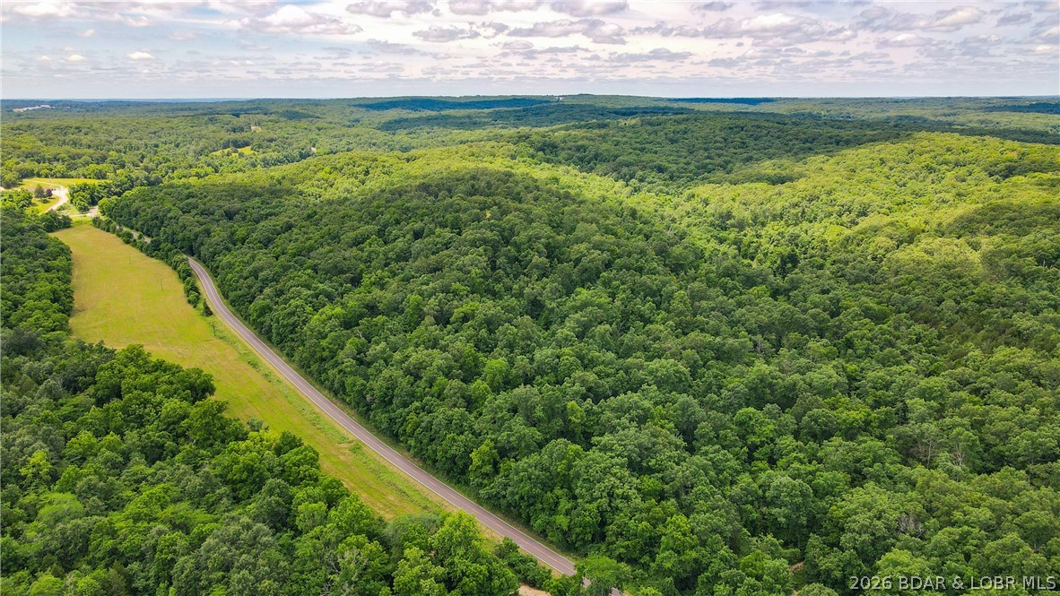 46.53 surveyed acres in the Gravois Mills / Versailles area. Properties like this are becoming hard to find, offering the perfect blend of recreation, convenience, and proven hunting success. This tract features north and south facing ridges, valleys, mature timber, thick bedding cover, established food plots, wet-weather creeks, and a trail system. The varied habitat creates excellent travel corridors and bedding areas, making this property extremely productive for hunting. It’s truly one of those places where you can step out of the truck and have a legitimate chance to harvest an animal the same day. The area is known for trophy whitetails and great spring turkey hunting. You will also enjoy mushroom hunting, artifact searching, hiking, and outdoor recreation, all just minutes from Lake of the Ozarks public boat ramps. The property also includes a fully finished container cabin with generator power, AC, propane heat, and a self-contained water system. Inside features a living area, kitchenette, bedroom, and bathroom, making it a comfortable base-camp for weekend getaways. With hardtop road frontage and multiple build sites, this property offers both accessibility and privacy.