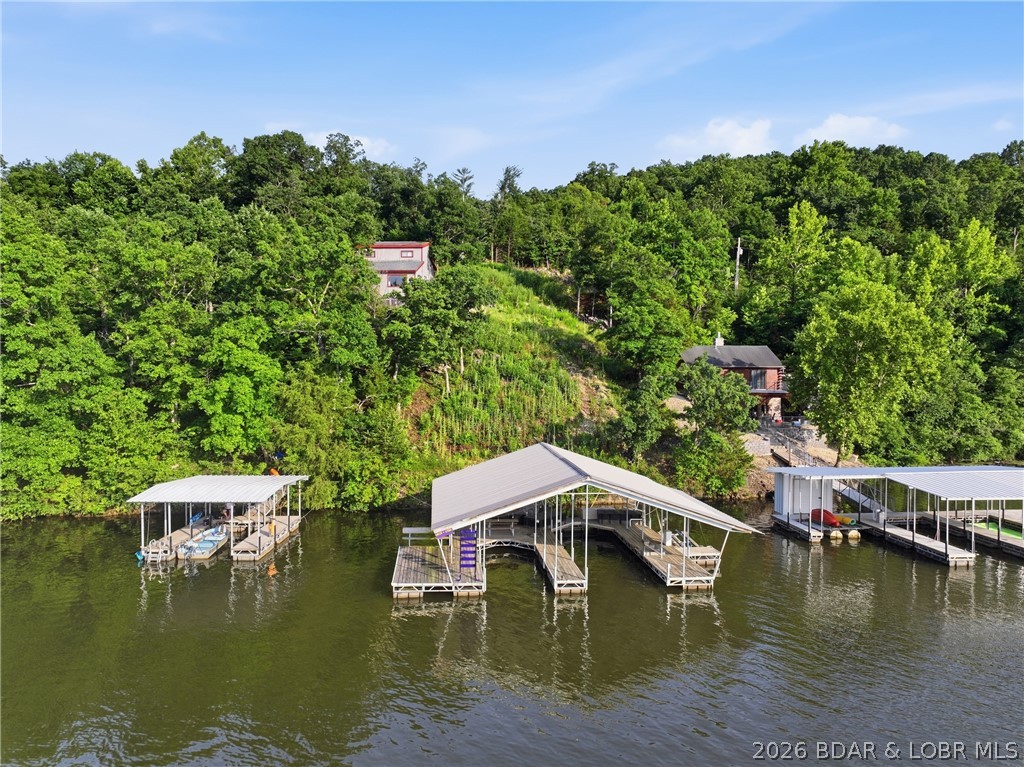 Build your dream lake home on this exceptional waterfront lot in the Little Niangua arm of the Lake of the Ozarks, offering the perfect combination of privacy, convenience, and year-round water access. Nestled in a quiet, peaceful neighborhood, this property features deep water all year long and is ready for you to start enjoying the lake lifestyle from day one. A spacious two-well dock is already in place, featuring one 12' x 36' slip and one 10' x 24' slip, providing plenty of room for multiple boats, personal watercraft, and all your lake toys. An established ATV road offers easy access from the building site down to the dock, making trips to the water simple and convenient. Community sewer and water connections already available on the property, saving you time and money for building your new home. Whether you're planning a full-time residence, a vacation home, or an investment property, this rare Lake of the Ozarks waterfront lot offers an incredible opportunity to build in one of Missouri's most sought-after lake communities. Enjoy stunning water views, excellent boating, fishing, and year-round recreation, all from your own slice of paradise.