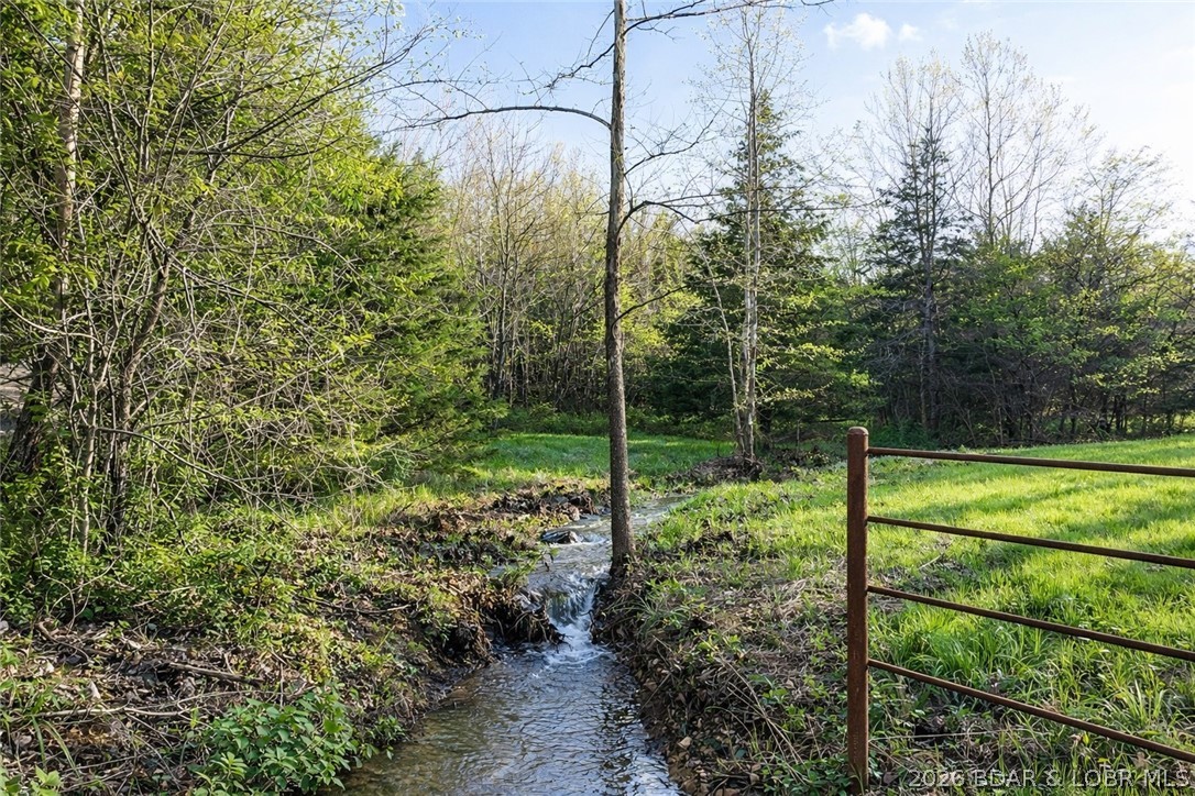This 197+/- acre property offers a rare combination of proven hunting, natural beauty, privacy, and exceptional build potential in one of the most desirable recreational corridors in central Missouri. Whitetail deer and turkey are abundant, with a well-positioned blind already in place. A strong mix of mature timber, open ground, and water creates outstanding wildlife habitat and multiple opportunities for food plots and stand locations throughout. A well-established trail system allows for easy access across the property for riding and exploring. The rolling terrain opens to multiple outstanding building sites with long-range views, ideal for a custom home or luxury cabin. Approximately 24+/- acres of open ground provide flexibility for food plots, small-scale farming, horses, or livestock, while the balance of the acreage is covered in mature timber that enhances privacy, habitat quality, and long-term land value. A year-round creek, pond, and seasonal stream further strengthen the property’s functionality, wildlife value, and appeal. A premium recreational and stewardship property offering multiple opportunities to enjoy, manage, and preserve the land for generations to come.
