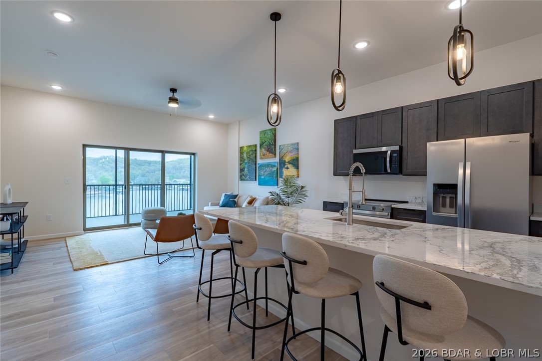 Enjoy the perfect blend of elevation and convenience in this third-floor Ember Ridge condo. This unit offers enhanced lake views while still providing easy access within the building. Featuring a spacious open-concept layout with 3 full bathrooms, a large pantry, and screened patio—ideal for both everyday living and hosting guests. Built with rare steel construction and designed with a clean, modern style, this brand-new condo stands out from anything else at the Lake of the Ozarks. Ideally located just minutes from several of the lake’s most popular waterfront restaurants and attractions. Dock slips and PWC slips available. Whether you’re looking for a personal getaway or a vacation rental investment, this unit offers flexibility to fit your needs. Photos are of Model Unit #205 and are used to showcase design and finishes—layout and selections may vary.