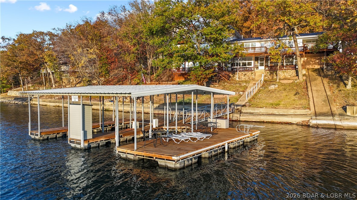 A must-see 10 Bedroom waterfront home. Check out this rare find in one of the most popular coves at the Lake of the Ozarks. Cove protected off the 3MM in Powerline Cove & by road via Horseshoe Bend, this lakefront property offers a unique opportunity to own a home boasting nearly 7,000 square feet that features 10 bedrooms and 7 bathrooms, making it a haven for large families or a prime vacation rental. There is 3 Levels of decking to take in the view and 170 feet of pristine lakefront. The property provides an expansive canvas for water activities, enhanced by a 2-well dock situated in a protected deepwater cove. The big dock envelope invites you to imagine creating the dock of your dreams and the perfect setup for a lakefront Waterside to give them something to talk about! The Detached 3-car detached garage includes an 840-square-foot workshop above, perfect for conversion into additional living quarters/game room. The home features high-end finishes, a Viking range, 7 Gas Fireplaces, & it's very own boat ramp. There is plenty of parking on this oversized lot that is over 1 acre. The Property is zoned R3, giving the property unique opportunities you don't often see on the water.