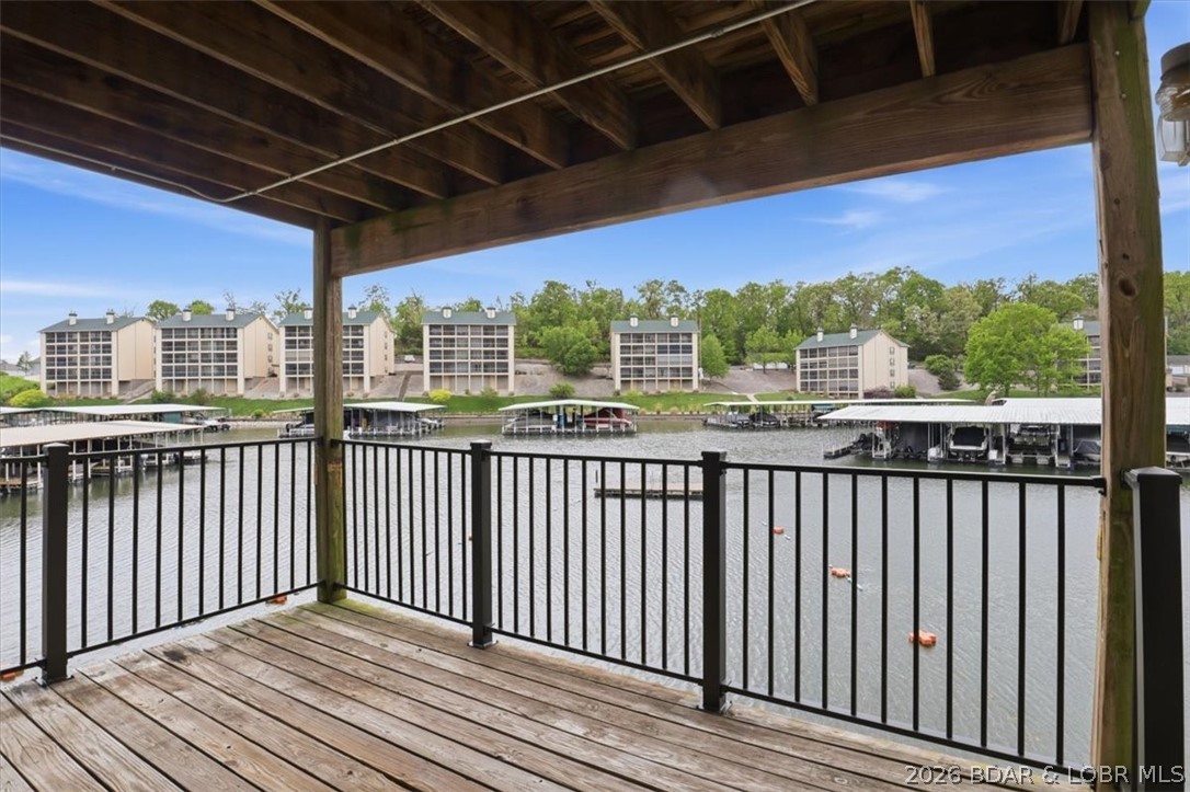 Welcome to this charming 2-bedroom, 2-bath condo offering approximately 840 sq ft of comfortable lakefront living. Recent updates include brand new carpet in the living room and hallway, adding a fresh touch to the interior. The layout is functional and inviting, with large floor-to-ceiling windows that showcase breathtaking views of the cove and fill the space with natural light. Step outside to your covered deck—perfect for enjoying morning coffee or unwinding in the evenings while taking in the peaceful waterfront setting. This unit is conveniently located just one level down from parking, providing easy access. Enjoy a wide range of amenities designed for year-round enjoyment, including a lakefront pool, tennis courts, playground, boat ramp, boat trailer parking, and even a fish cleaning station—everything you need to fully embrace lake life.