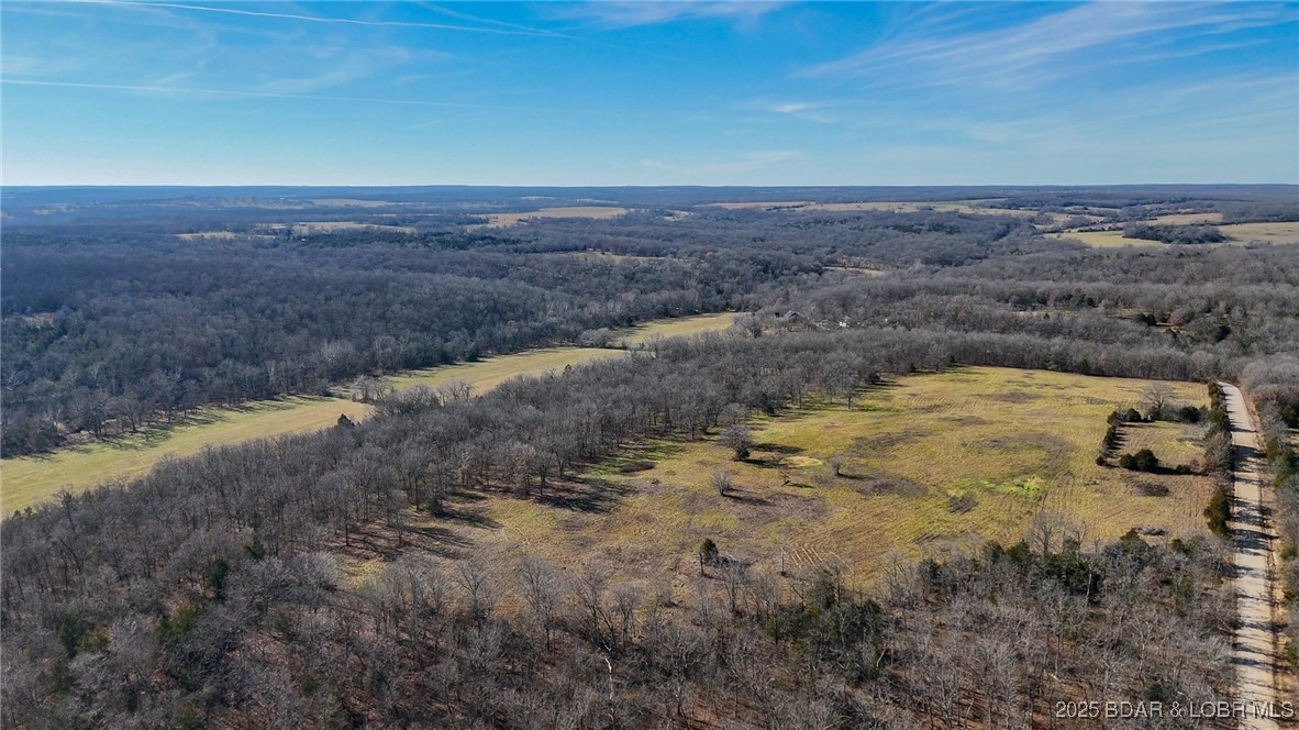 Step into quiet beauty of the Missouri countryside with this 308-acre property, ideally located just 30 minutes from the Lake of the Ozarks. Offering a rare blend of productivity, water, & recreation, this land is well suited for agriculture, hunting, or a private homestead. Over 80+ acres of open pasture currently produces more than 180 round bales of hay annually, providing a strong foundation for a cow-calf operation/hay production. This property is exceptionally well-watered, featuring a year-round pond & a substantial wet-weather creek, supporting livestock & attracting abundant wildlife. The remaining acreage offers timber, cover, & seclusion, creating excellent hunting opportunities & a peaceful rural setting with long-term land value. A 100-year-old farmhouse and several older barns remain on the property, adding historical character & potential for restoration. The main barn is equipped with water & 220-volt electric service, offering functional value for future improvements. Whether you’re looking to expand an ag operation, or invest in a large tract of Missouri land near the Lake of the Ozarks, this property offers space, resources, & the opportunity to make it your own.