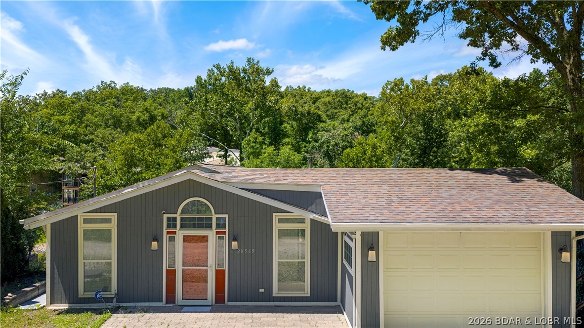 If your goal is simple—get to the lake—this 5 MM lakefront home is ready for weekends, summers, or full-time lake living. The screened porch, expansive covered decks, and peaceful cove setting make it easy to settle in and enjoy the pace of lake life. Upstairs offers 3 bedrooms and a full bath with attached laundry. Two of the bedrooms open directly onto the screened porch, giving you a place to relax and enjoy the view. The walkout lower level features an open kitchen, dining and living area, a second full bath, and direct access to the covered deck, creating plenty of room to gather with family and friends. Easy access to the crawl space and a convenient outdoor storage area provide plenty of room for your lake gear, tools, and seasonal items. There's room to make it your own, giving the next owner the opportunity to update it over time. The package is made complete with an attached garage, concrete seawall, and private dock. If a quiet cove is what you are looking for, you'll appreciate what this setting has to offer.