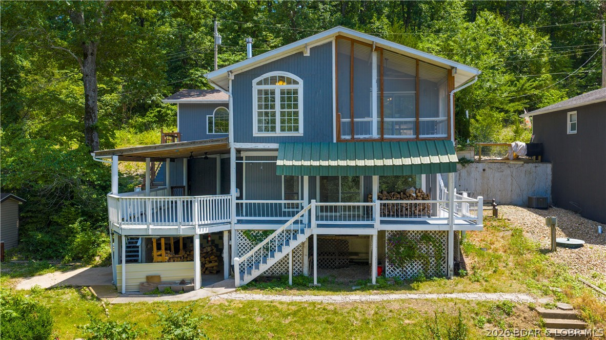 If your goal is simple—get to the lake—this 5 MM lakefront home is ready for weekends, summers, or full-time lake living. The screened porch, expansive covered decks, and peaceful cove setting make it easy to settle in and enjoy the pace of lake life. Upstairs offers 3 bedrooms and a full bath with attached laundry. Two of the bedrooms open directly onto the screened porch, giving you a place to relax and enjoy the view. The walkout lower level features an open kitchen, dining and living area, a second full bath, and direct access to the covered deck, creating plenty of room to gather with family and friends. Easy access to the crawl space and a convenient outdoor storage area provide plenty of room for your lake gear, tools, and seasonal items. There's room to make it your own, giving the next owner the opportunity to update it over time. The package is made complete with an attached garage, concrete seawall, and private dock. If a quiet cove is what you are looking for, you'll appreciate what this setting has to offer.