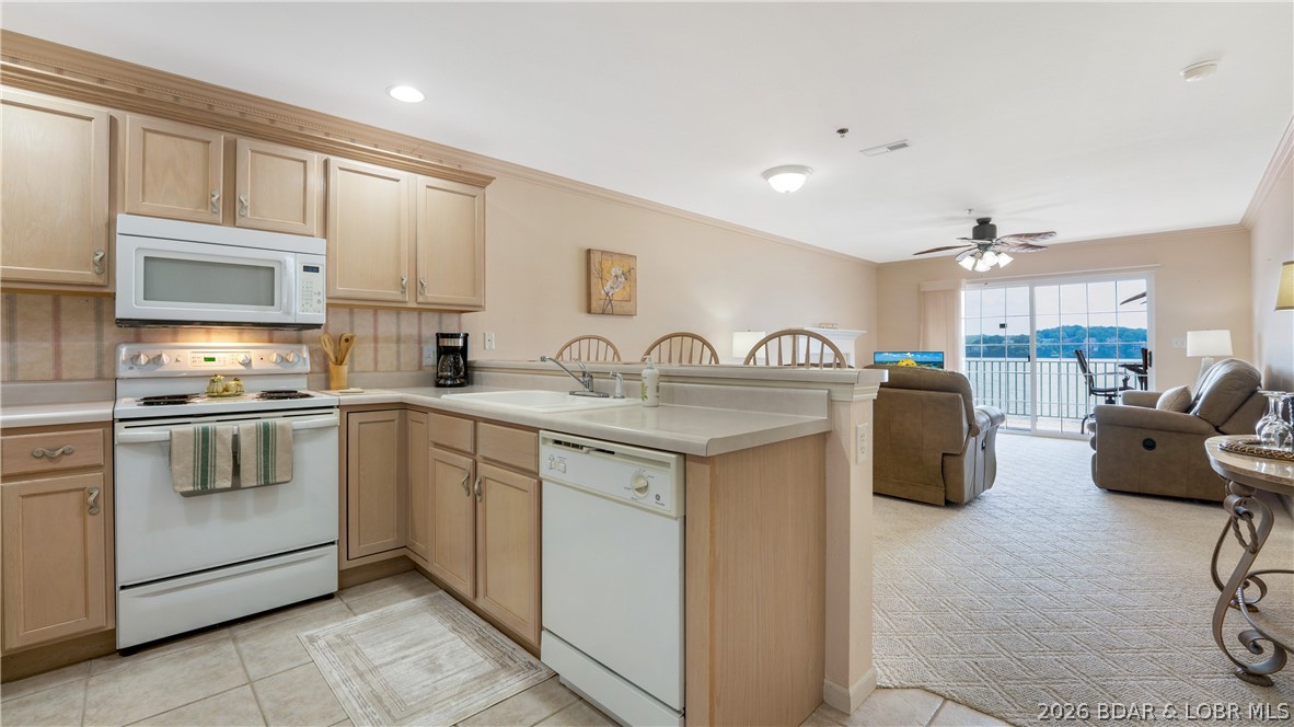 Walk in with no steps, set your bags down, and instantly feel the stress melt away. Lovingly cared for, this three-bedroom, two-bath condo offers the perfect blend of comfort, convenience, and breathtaking main channel views. Tucked inside a quiet gated community, it’s the ideal place to relax, entertain, and enjoy lake life at its best. The open layout creates an inviting space for gathering with family and friends, while the million-dollar view provides a stunning backdrop from sunrise to sunset. Whether you’re enjoying peaceful mornings with coffee or unwinding after a day on the water, this condo was made for making memories. The well-maintained complex features a community pool and dock with swim platform. Boaters will love the included 12x32 boat slip, with the option to convert back to a 14x40, plus PWC port. Conveniently located near the Bagnell Dam Strip, you’ll enjoy quick access to shopping, waterfront dining, and popular lake destinations by both land and water. Seller has paid special assessment.