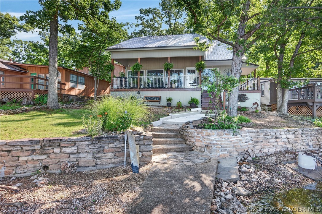 Experience the perfect blend of natural beauty and modern comfort in this stunning lakefront cottage. Nestled among mature shade trees, offering an idyllic escape with an exceptional outdoor living space and totally remodeled from top to bottom, including custom kitchen cabinets, granite counters, and a dining island, updated appliances, and so much more. Originally a 2-bedroom, an additional floor was added that now accommodates a large bunkroom. Bathrooms have been tastefully updated to perfection, along with new flooring throughout the entire home.