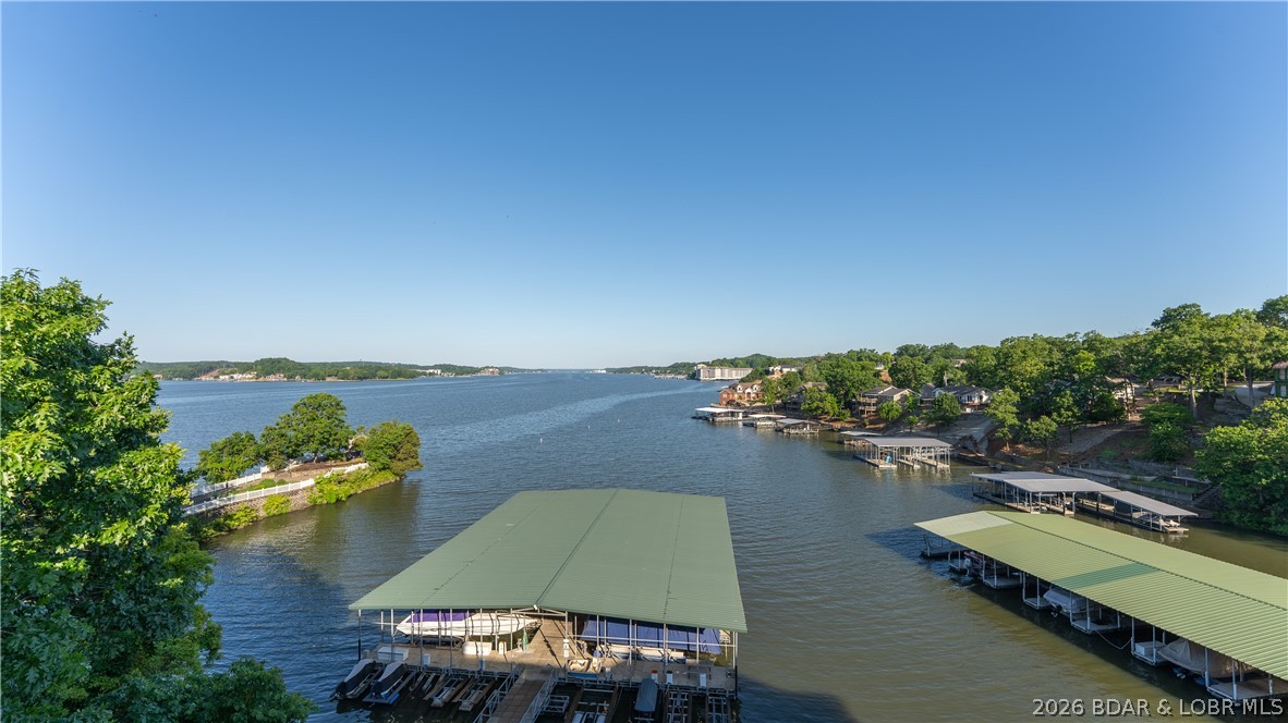 GOLF CART TO YOUR SLIP - Effortless access, just a few steps from your unit to your golf cart.  Drive your golf cart on the dock and park right at your 14x36 boat slip.  Be prepare to be captivated by miles of main channel views from this stunning Lake of the Ozarks condo.  Whether you’re heading out for a sunset cruise or coming home after a long day on the water, the transition from your front door to the captain’s chair has never been easier. Enjoy legendary sunsets from your private deck, or a short trip to the nearby Bagnell Dam strip for the area's best dining and nightlife.   Brand new flooring and fresh paint in 2024, offering move in ready feel.  This condo is loaded with a one car garage with additional storage and relaxing hot tub for owners to enjoy.