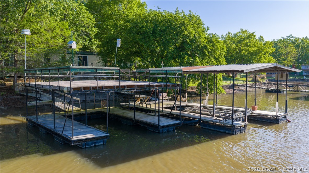 For buyers seeking a lakefront property that allows for future expansion or added functionality, this offers the space & flexibility to make that possible. It is uncommon to find lakefront, usable land, & additional structures at this price point. Offering approximately 147’ of lake frontage in a Simons Point location at the 47 MM, with desirable access by both land & water. The property also features a private boat ramp & 2 docks, giving you convenient lake access & use. The 3 bdrm, 1.5 bath home features a vaulted ceiling & 1 level living. Offered in its present condition, it allows the next owner to update at their own pace while enjoying the lake lifestyle from day one. What truly sets this property apart is the space, not just lakefront, but room to grow, build, store, & make it your own. The detached 30’ x 30’ garage with a rec space & deck above provides an opportunity for additional living quarters or rental use, while the second tier parcel includes a 30’ x 40’ shop, an increasingly valuable feature as storage at the lake is often limited. This is an opportunity for investors, builders, or buyers seeking a renovation or value add property in a strong lakefront location.