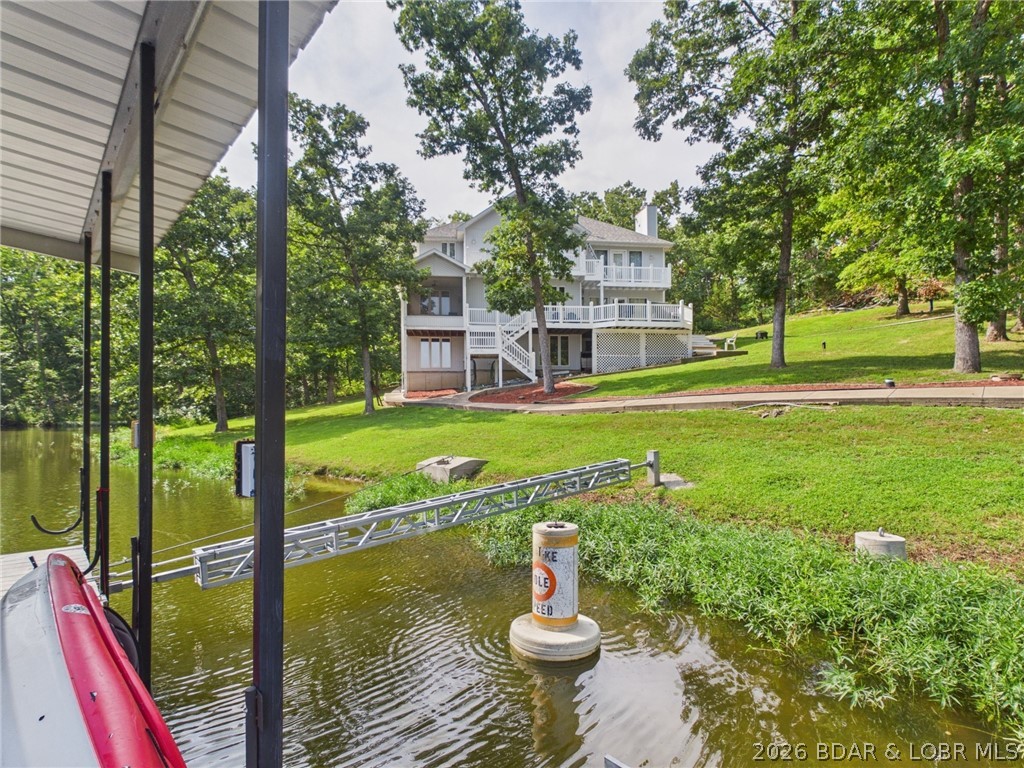 This premier multi-level 5-bedroom, 4-bath lakefront retreat with a rare 3-car garage is tucked in a quiet cove at the 36MM —ideal as a primary residence, vacation home, or high-capacity short term rental(STR), with only one neighboring home & NO HOA! Set on a 1.45-acre lot with ample parking and space to create more, its location on the "Quiet Side" of Lake of the Ozarks is unbeatable: just minutes by water to hotspots like Capt. Ron's, The Cave Bar, & Bear Bottoms, and a quick drive to shopping, Ozark Amphitheater, & Ha Ha Tonka State Park.  The main level is built for entertaining with a chef's kitchen, formal dining, living room, billiards room, and deck overlooking 195' of prime lakefront. The middle-floor primary suite features a 3-sided propane fireplace, walk-in closet, & spa-like bath. Upstairs there's 3 more bedrooms & a full bath, while the walkout lower level features a large family room, kitchen, 3/4 bath, & a bedroom large enough for 2 king beds. Outside, enjoy your ultimate lake setup: a covered dock with 10x28 slip, wet steps, double PWC lift, & dock shed, plus a whole-house backup generator & fresh water tank! This versatile home is ready for turn-key lake living!