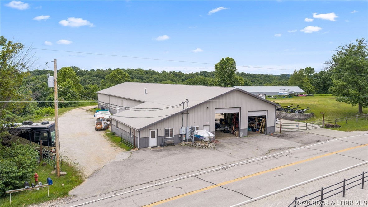 Boasting a potential $6,000/month in rental income & situated on a generous 2.7 acres, this incredible commercial investment opportunity awaits.  It's located in the absolute best spot on Horseshoe Bend in Lake Ozark. Already an existing marine service center & storage business that generates $15,000 yearly. The marine service business is also available for purchase. This prime property features a massive 8,800-square-foot main building divided into four highly functional units. This includes a substantial 4,300-square-foot main shop equipped with 12x12 & 14x14 foot garage doors, alongside three 1,500-square-foot rental units that offer immediate income potential.  Expanding the footprint are two additional buildings: a 1,500-square-foot insulated structure and a 3,600-square-foot storage building, both outfitted with garage doors. Each unit also has it's own bathroom facility. Combining a highly coveted Lake Ozark location (outside the city limits) with exceptional acreage, versatile layouts, and this commercial property is perfectly positioned to support a thriving marine enterprise, a high-capacity storage business, or a lucrative multi-tenant rental portfolio.