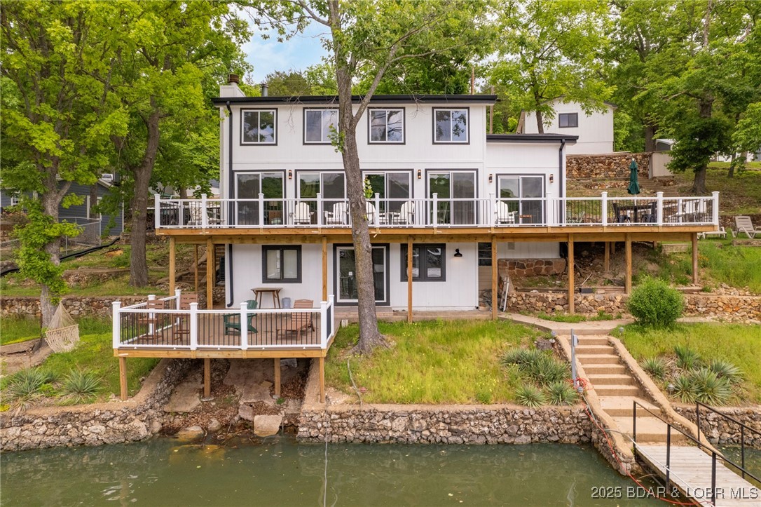 Delightful 4-Bedroom, 2-Bath Lakefront Getaway with Sweeping Views in peaceful cove setting! Enjoy those stunning panoramic lake views from expansive lakeside decks—perfect for morning coffee or evening sunsets. This charming retreat was remodeled in 2024 with new Trex decking, new flooring and sliding glass doors, new paint and carpet throughout.  Kitchen has also been remodeled with all new appliances. Inside you’ll find a cozy yet spacious layout; while outside offers a detached 1-car garage and plenty of additional parking for guests. Enjoy relaxing on your private 2-Well dock or take a dip, or cruise the lake all day long.  Whether you're looking for a serene weekend escape or a place to host unforgettable gatherings, this property will make your lake life dreams a reality.  At full price, buyer can have $40,000 income from rental bookings already scheduled throughout the summer.