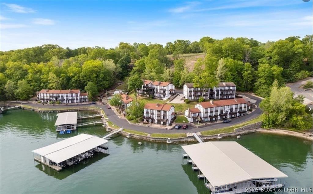 Looking for the perfect lake retreat? This Osage Heritage condo delivers on every front. The seamless open floor plan connects the open kitchen to the living room, creating a bright, airy environment for family time. The primary bedroom is a true standout, offering main-channel views that make every morning feel like a vacation. There is plenty of room to host friends and family with two additional bedrooms, open floor plan and easy access.  Complete with a boat slip, boat hoist, lakefront deck, and access to the community pool nestled in a wooded park-like setting, this condo offers the perfect balance of social space and private retreat.