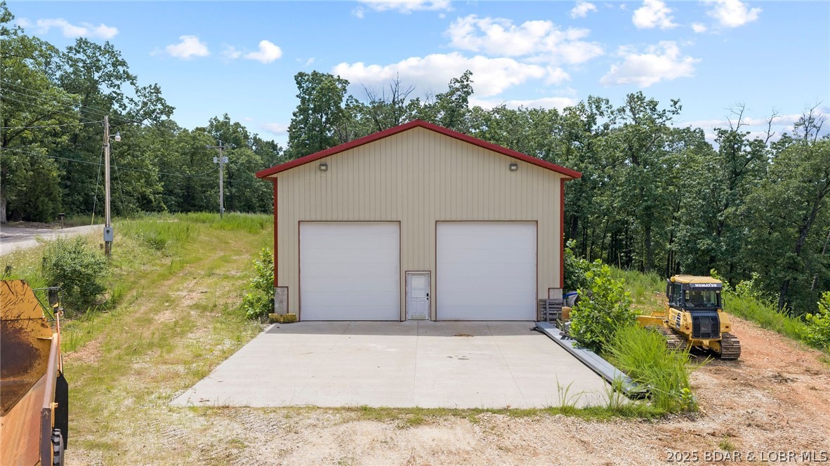 Discover this exceptional 4,000 sq ft Shouse/commercial/industrial shop at 835 Greenview Dr in Camdenton.  Located in Greenview just a few miles off of Highway 5.  Situated on a flat 8.11 acres with no restrictions or subdivision requirements. Perfect for an RV, storage, commercial business, or building a Shouse/residence, there is plenty of room to build and expand. The land is also suitable for recreational activities and hunting. Built for heavy use, the shop features two spacious 14' garage doors and 21' ceilings. It is equipped with 480-volt, 3-phase electric and a new mini-split system providing heat and air conditioning. The facility boasts extra-thick 8-inch concrete floors and a matching driveway, both poured with a durable 7 sack mix. Utilities include a shared well and a 1000-gallon septic system, making this property versatile for demanding operations or a unique live/work setup.