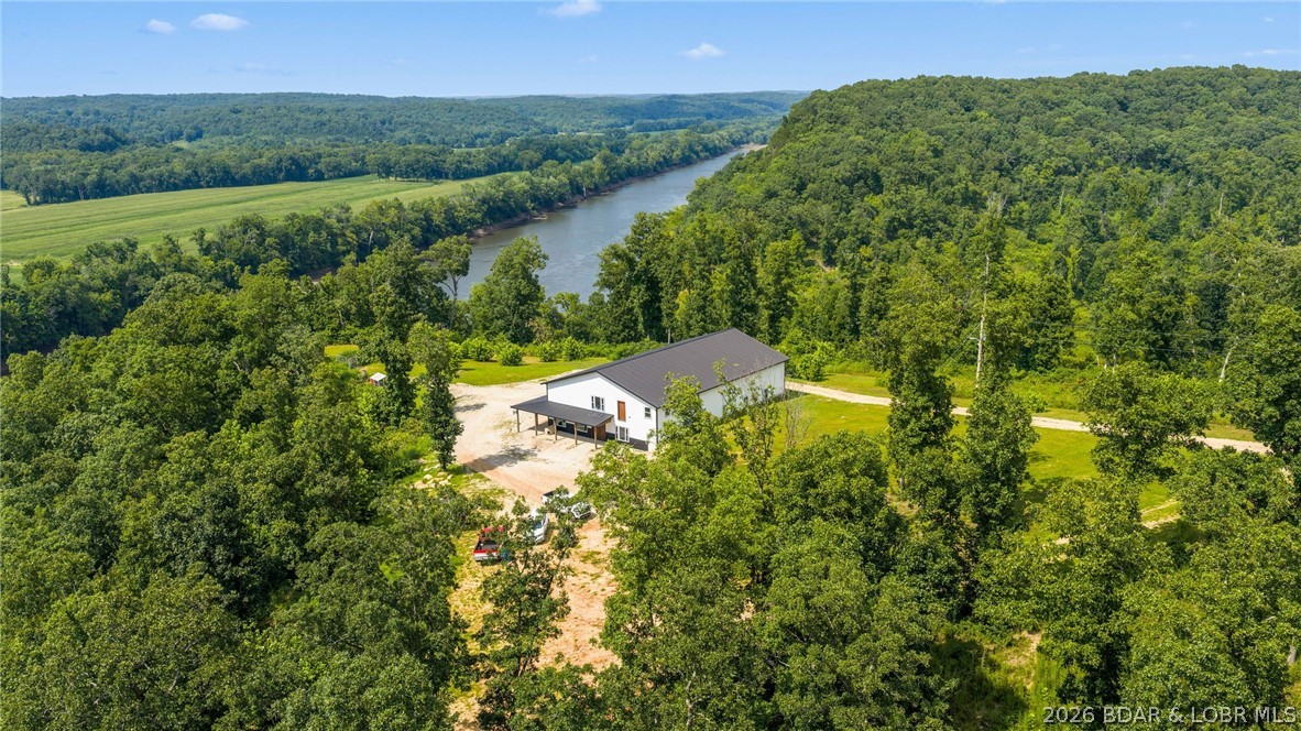 Escape the noise and embrace ultimate freedom in peaceful Tuscumbia, MO. This stunning 4,000-square-foot "Shouse" (shop-house) sits on 90 expansive acres of pristine land, offering a rare combination of modern country living and unmatched versatility—with absolutely no HOA or property restrictions. The property features a beautifully designed 1,500-square-foot living quarters, offering a highly functional 3-bedroom, 2-bathroom layout with a modern open floor plan and bright interiors perfect for comfortable country living. Seamlessly attached is a massive 2,500-square-foot premium shop space, providing a clear-span canvas ready for a home business, heavy equipment, boat or RV storage, or the ultimate workshop setup. Beyond the structure, the land itself boasts a spectacular, panoramic view of the winding Osage River. With 90 acres to your name, you will enjoy unparalleled privacy, abundant local wildlife, and total freedom to hunt, farm, build, or expand exactly as you see fit. Whether you are looking for a private homestead, a workspace for your passion projects, or a scenic river-view retreat, this unique property delivers the unrestricted lifestyle you’ve been dreaming of.