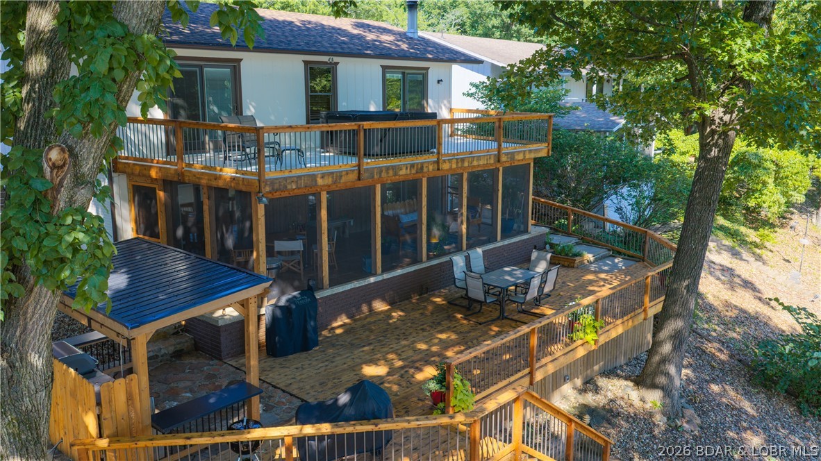 Lake front living at it's finest on the 36 Mile Marker.  Experience the perfect blend of comfort and breathtaking lake views in this exceptional lakefront home.  With cove protection and stunning views of the main channel, this property offers the ideal setting for both relaxation and recreation.  This beautiful homes features 2 spacious guest bedrooms, full bathroom, and the large primary en suite - all bedrooms have a lake view.  On the lower level, the large living room is perfect for entertaining and relaxing. The beautifully remodeled kitchen features new cabinets, countertops, flooring, island workspace, and a convenient walk-in pantry.  The living area extends outside with the newly remodeled screened-in deck-Oh the view!! The outdoor kitchen is next to the sun deck for all you cooking enthusiasts - yes please!  Easy steps down to the private 2-well dock with swim platform-hoist included.    The view is fantastic!  The common area provides for boat trailer parking and the playground.  Whether you are looking for a full-time residence or a weekend retreat, this lake front beauty delivers the ultimate waterfront lifestyle - meticulously maintained and ready for you to enjoy!