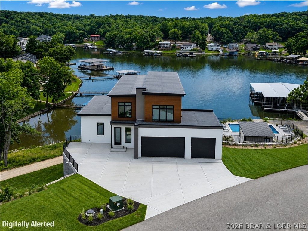 Welcome to THE COVE - A stunning Luxury Home Development at the Lake of the Ozarks! Unlike most new construction at the Lake, homes at The Cove feature ultra modern architecture & design. This custom new build is centered on a large double lot with a coveted 180' of waterfront for your own private dock of your dreams in a scenic cove at the 8mm. Featuring an expansive floor plan with 3 tiers of living space that seamlessly flows to the outdoor patios for entertaining. Distinctive contemporary features with stunning kitchen, high end finishings & attached 3 car garage. Master Bedroom Ensuite complete with tile shower & oversized master closet. 5 additional guest bedrooms & baths plus the bonus of having 2 washer/dryers. The development will feature amenities including a golf cart path, community dock, manicured landscaping and a community pool in Spring of 2026! Located down Horseshoe Bend this home offers tons of privacy while still being close to some of the most popular dining & entertainment the lake has to offer like Camden, Shady Gators, Alhonna, Tap & Grill, & 2 of Missouri's Top 5 Golf Courses- The Cove & The Ridge. Don't miss your chance to own this beauty.