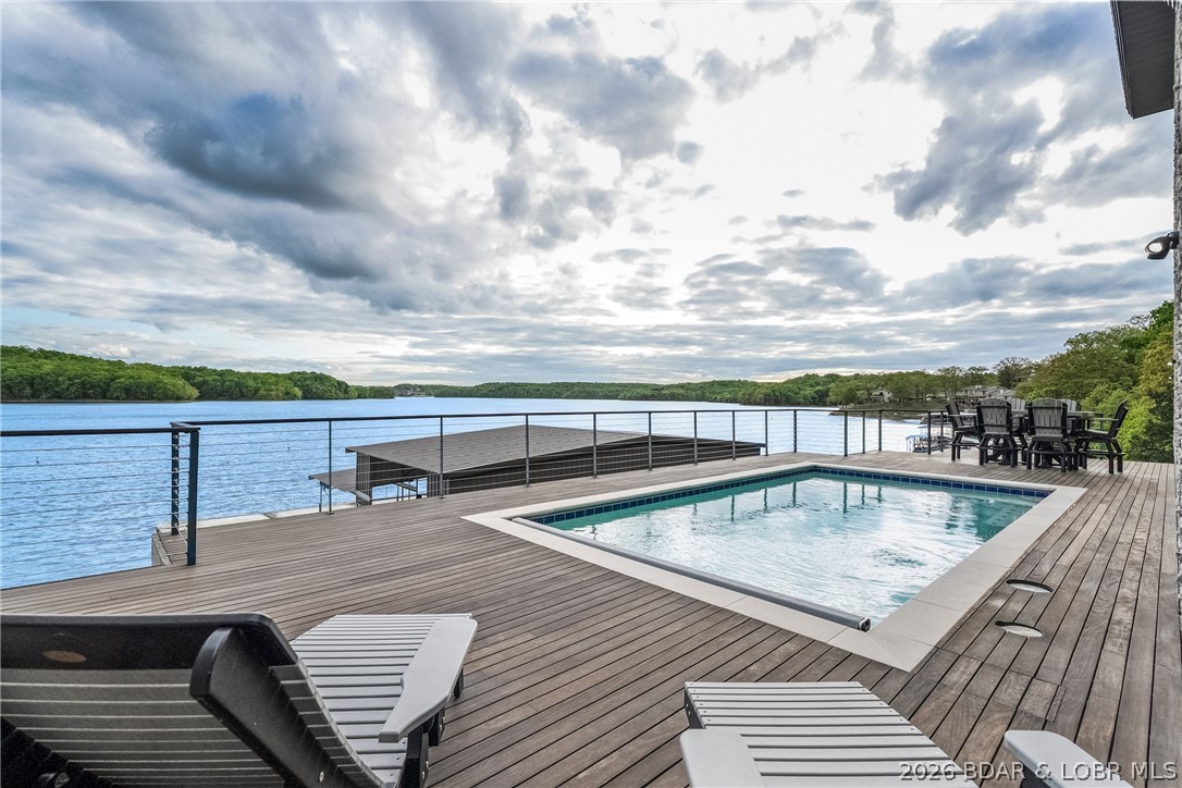 Beauty & nature bring peace to the soul at 777 Malibu. Set facing over 80 acres, & 1700 ft. of preserved state park shoreline this retreat offers forever views & untouched scenery. Not simply a lakefront home, it's a rare architectural statement. Soaring ceilings, hardwood floors, & walls of glass pull the lake into every living space. This exceptional lakefront estate couples' fun with function. Each bedroom is a private lakefront ensuite w/ 5-star comforts. The chef's kitchen showcases crisp white cabinetry blended w warm wood accents; eloquent granite & a statement range, designed for premium functionality. Resort-style pool framed by rich Brazilian IPE decking appears to spill directly into the lake giving a luxurious & enduring experience for family & guests. Extraordinary 4,000+ sq ft dock is an entertainer’s dream w/ 18x52 cruiser slip, 12x32 slip customizable to 16x40, PWC slips, integrated sound system, slide & dive platform. City utilities, no HOA, & vacation rental opportunity.  Minutes to lakefront & off-water dining, hospital & clinics, shopping & attractions!  777 Malibu is a luxurious home in an irreplaceable location, offering lasting value for generations to come.
