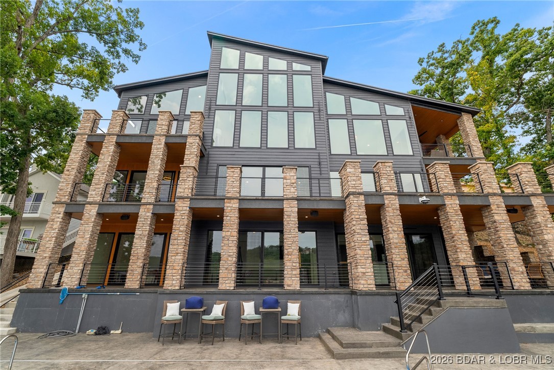 Luxury, location, and lake views come together in this stunning new construction at the 4 MM in the highly sought-after Four Seasons community. This impressive lakefront home delivers breathtaking views and unforgettable design at every turn.

Spanning three beautifully designed levels, the home is built for both everyday comfort and elevated entertaining. The main level features soaring vaulted ceilings, floor-to-ceiling windows, and a striking double-sided fireplace connecting the living and dining spaces. The gourmet kitchen steals the show with high-end appliances, a dramatic waterfall quartz island, and sleek, modern finishes.

Entertain with ease thanks to two family rooms, a private movie theater, wet bar, and kitchenette—ideal for hosting guests or large gatherings. Outdoor living shines with two expansive decks, an in-ground pool, and space to create your dream dock.

The primary suite is a true retreat, complete with a spa-like walk-in shower and stand-alone soaking tub. A 3-car garage, additional parking, and close proximity to Lake Ozark’s best dining, shopping, and attractions make this home truly unbeatable.

*Pool Bar is expected to be completed April 2026*