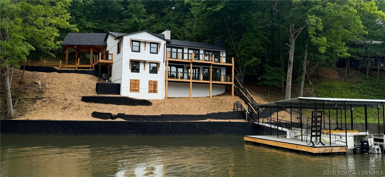 Where Lake Living meets Land Ownership! Welcome to Lake Ranch, a rare waterfront retreat tucked away in desirable Miller’s Cove in the heart of Osage Beach. Situated on approximately 2 acres with 214 feet of shoreline, this extensively remodeled home offers 4,903 sq. ft., 5 bedrooms including a flexible bonus room ideal for a future bunk room, 4 baths, and a 3 1/2-car garage. The open-concept design features vaulted tongue-and-groove wood ceilings, a stunning custom kitchen with new Quartz white countertops, spacious gathering areas, two wood-burning fireplaces, and beautiful lake views. Recent updates include a new roof, HVAC, septic system, flooring, fixtures, and extensive interior and exterior renovations. Enjoy multiple lakeside decks, a private 2-well dock, and a protected cove setting. An additional 20-acre parcel is available following the home sale, creating the opportunity for approximately 22 acres and over 500 feet of shoreline. Featuring a 2 well dock! A truly one-of-a-kind lakefront estate.