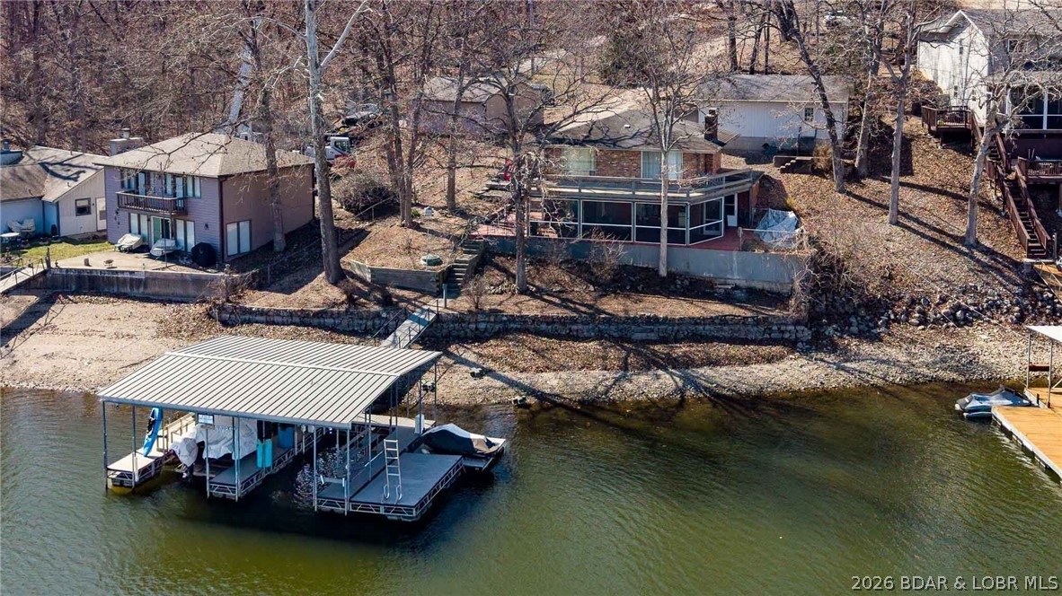 Nestled at the 8 MM in Buck Creek Cove,  this lakefront retreat offers the best of both worlds—big protected cove and year-round water. If you’ve been waiting for that “this is the one” feeling, this might be it.

This beautiful all brick home with detached 2 car garage has been thoughtfully updated with major improvements you’ll truly appreciate. The main level features brand-new LVP flooring and new windows that fill the space with natural light while boosting energy efficiency. Central heating and cooling have been added for year-round comfort, making lake living easy in every season.

Both bathrooms have been completely remodeled with fresh, modern finishes. In the kitchen, you’ll find a new dishwasher & garbage disposal, ready for entertaining after long days on the water.

The big-ticket items? Already handled. Updates include a new pressure tank on the well, new septic pump, aerator, and laterals, plus a new shallow well pump on the dock—giving you peace of mind so you can focus on enjoying the lake.

Relax outside on the screened in patio or step down to the dock for all your summer fun. Just a short boat ride away from Shady Gators, Tap & Grill & Franky & Louies