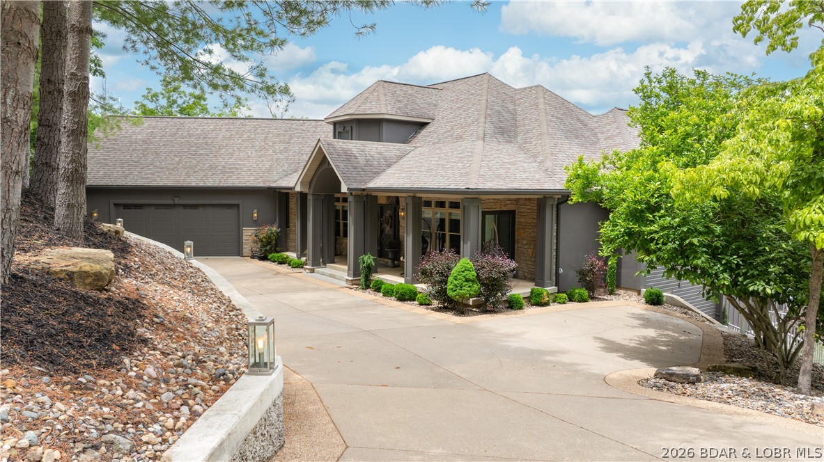 Experience luxury lakefront living on a scale rarely found at Lake of the Ozarks. This extraordinary estate offers nearly 9,000 square feet of beautifully remodeled living space featuring 7 bedrooms, 6 bathrooms, and breathtaking lake views from nearly every room. Showcasing stunning tile work, soaring timber accents, rich wood details, and walls of glass spanning multiple levels, the home blends elegance with relaxed lakefront comfort. Designed for entertaining, you'll find two full kitchens, two custom bars, expansive gathering areas, and an incredible game room perfect for hosting family and friends. Situated on a spectacular one-acre lot with an impressive 354 feet of shoreline, the outdoor amenities are equally remarkable. Enjoy the sand beach, beautifully landscaped grounds, multiple outdoor entertaining areas, basketball hoop and a lakeside fire pit. Three separate driveways provide exceptional convenience and parking. The show-stopping dock features three boat slips, a large swim platform, and a unique enclosed waterfront bar designed for unforgettable days on the lake. A rare lakefront retreat that must be seen in person to fully appreciate.
